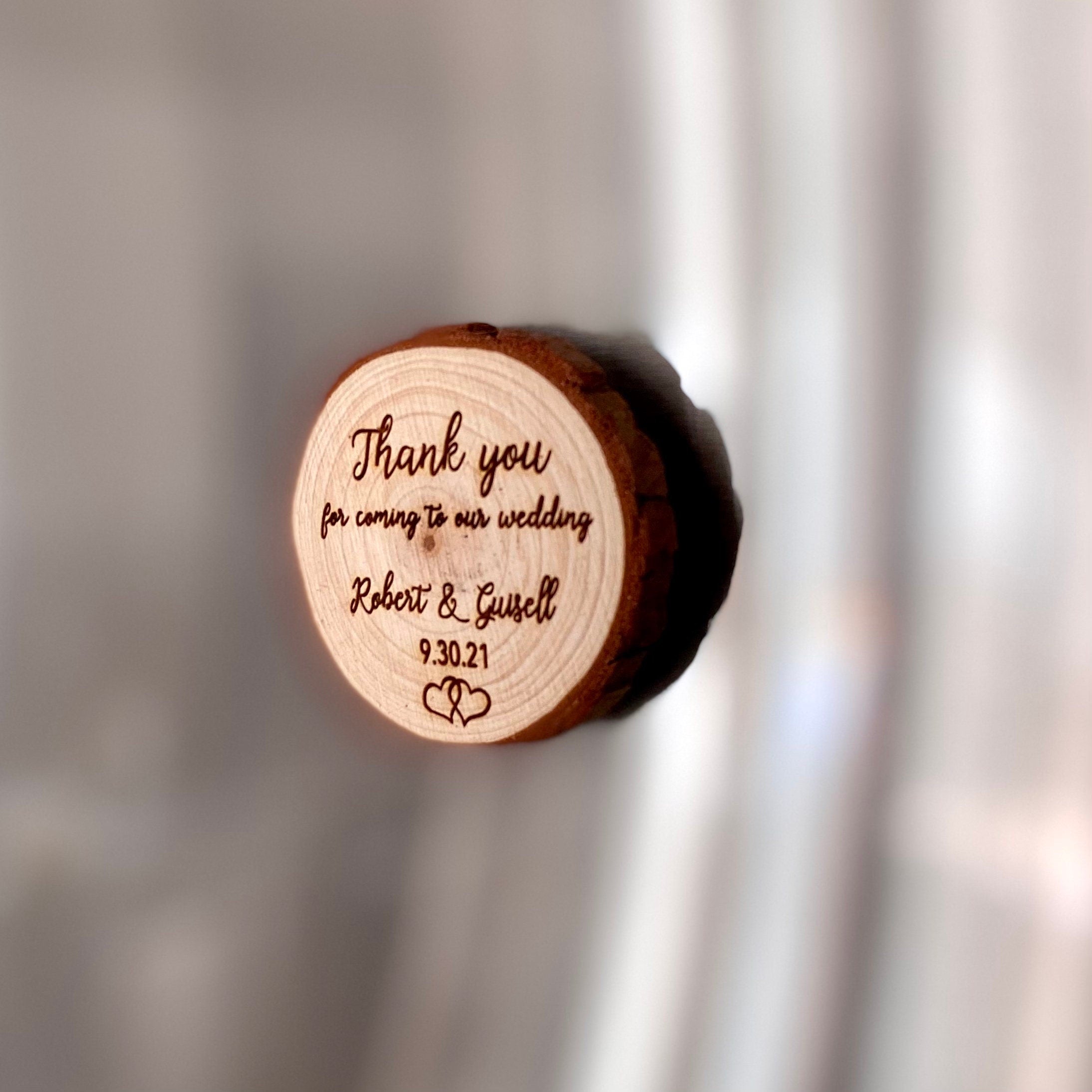 Custom engraved wood slice wedding favor with magnet, featuring personalized names and date.
