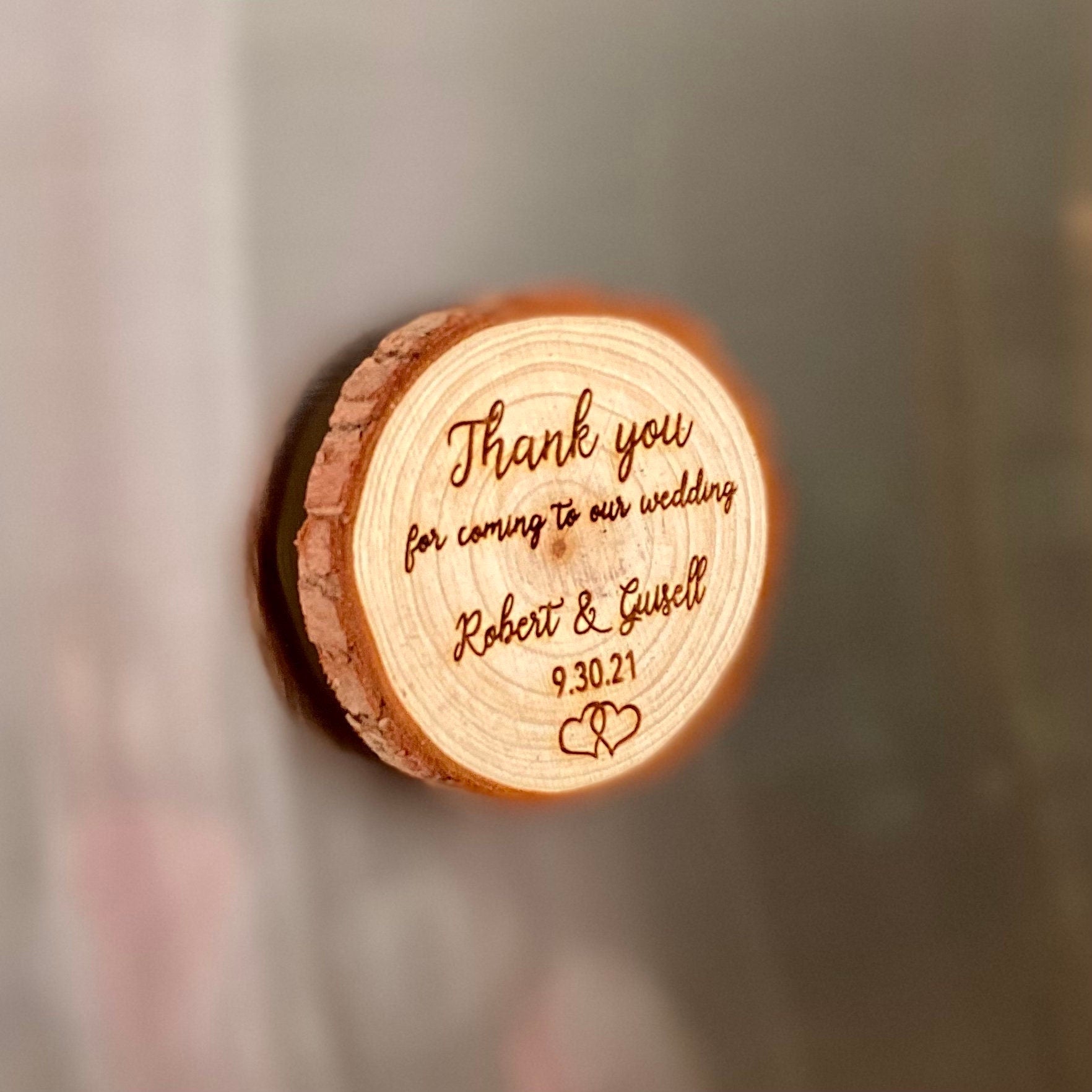 Custom engraved wood slice wedding favor with magnet, featuring personalized names and date.