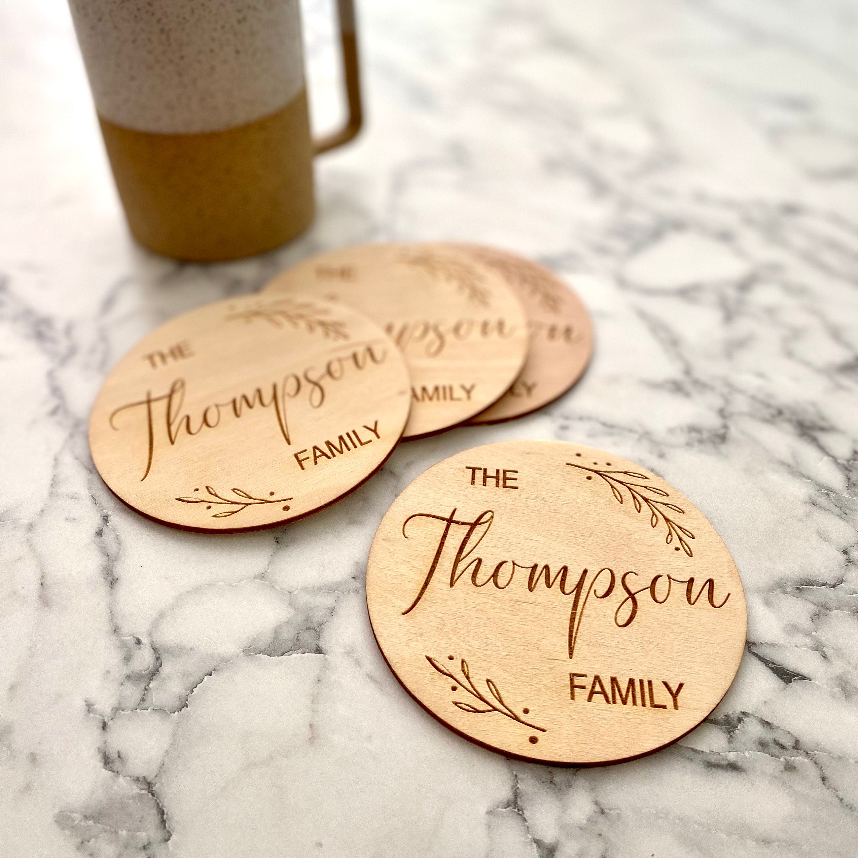 Custom Family Name Engraved Wood Coaster Set featuring elegant leaf border and personalized engraving.