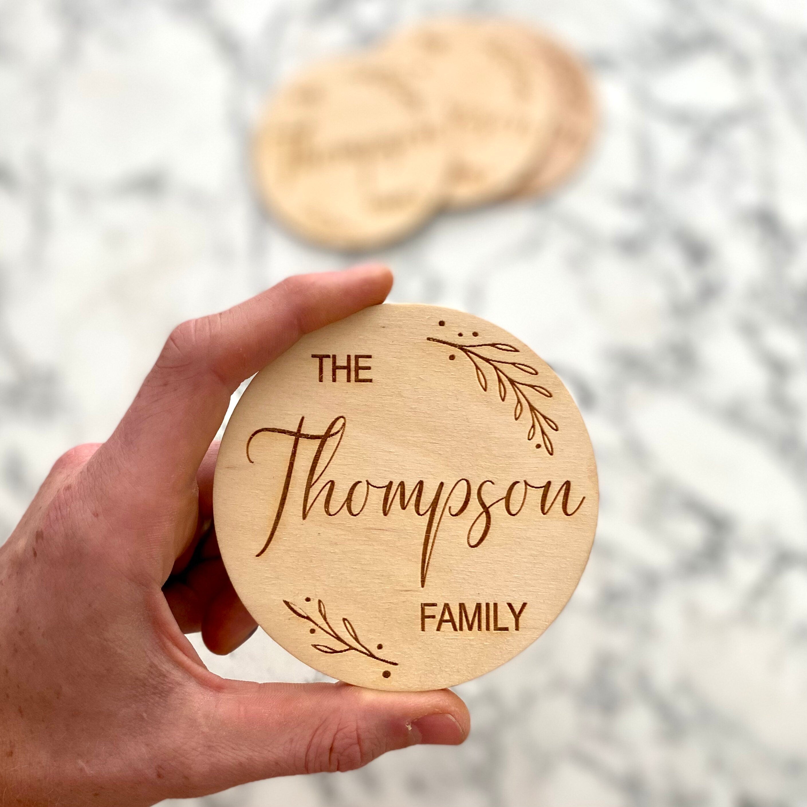 Custom Family Name Engraved Wood Coaster Set featuring elegant leaf border and personalized engraving.