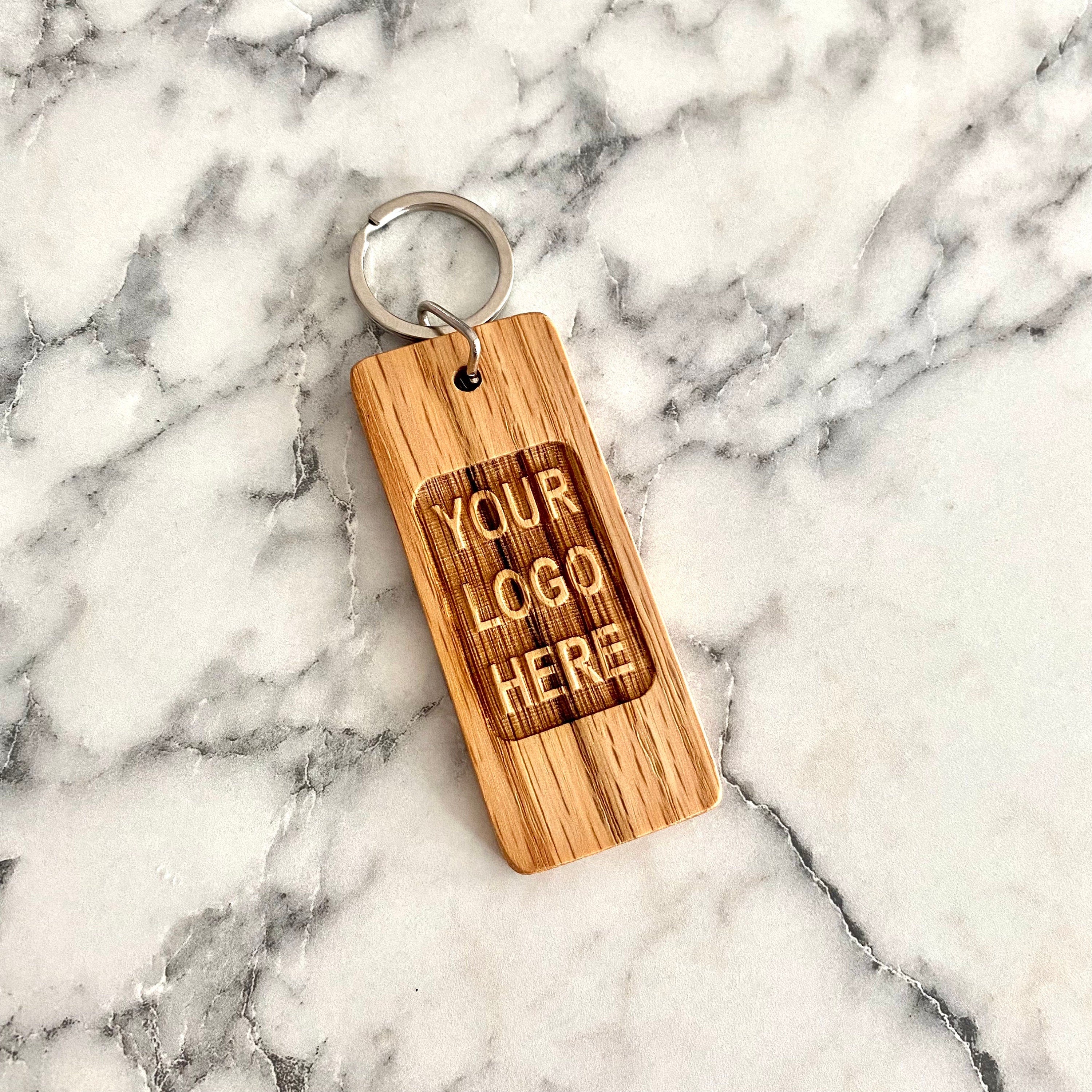 Custom logo engraved wood keychain made from solid oak, showcasing a personalized design.