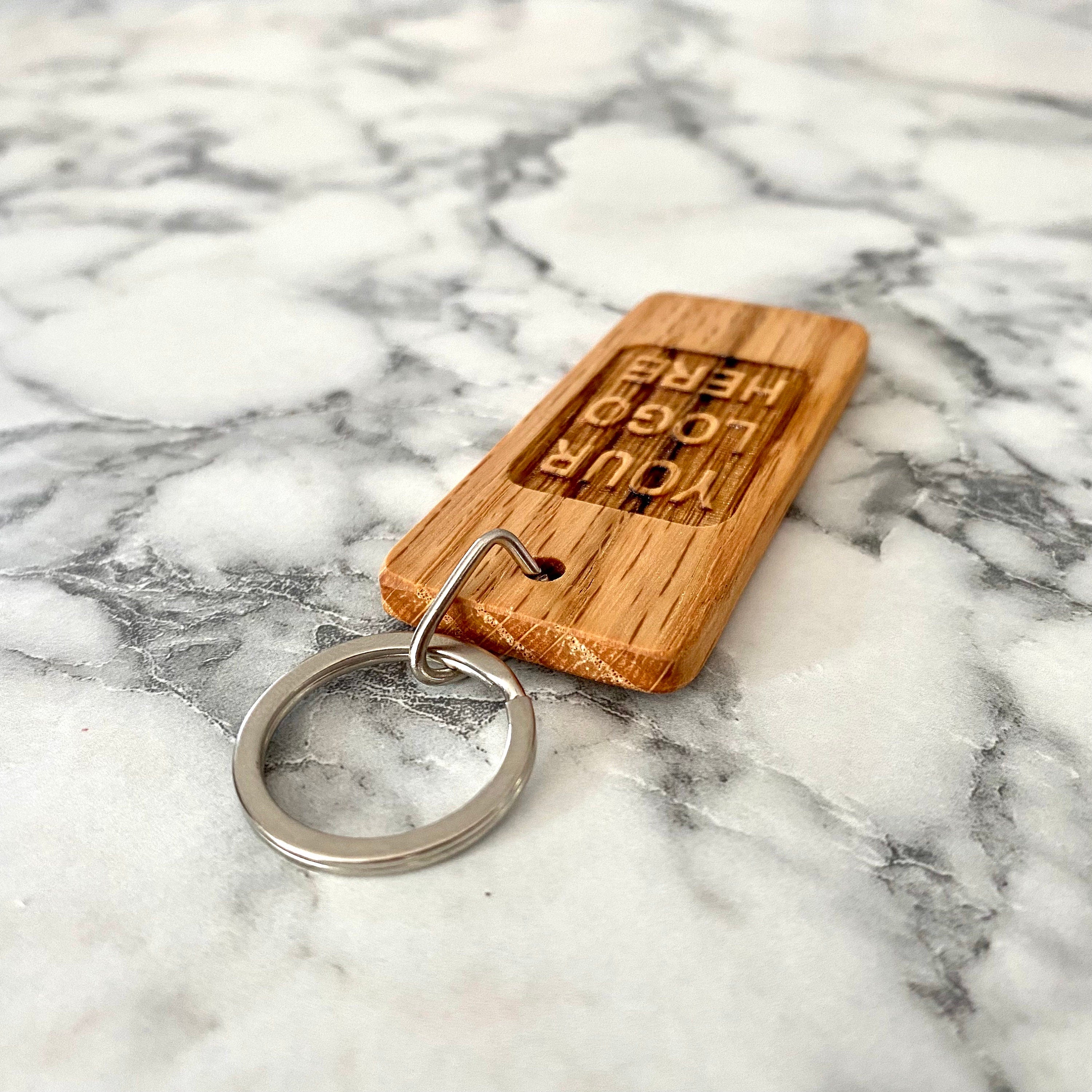 Custom logo engraved wood keychain made from solid oak, showcasing a personalized design.
