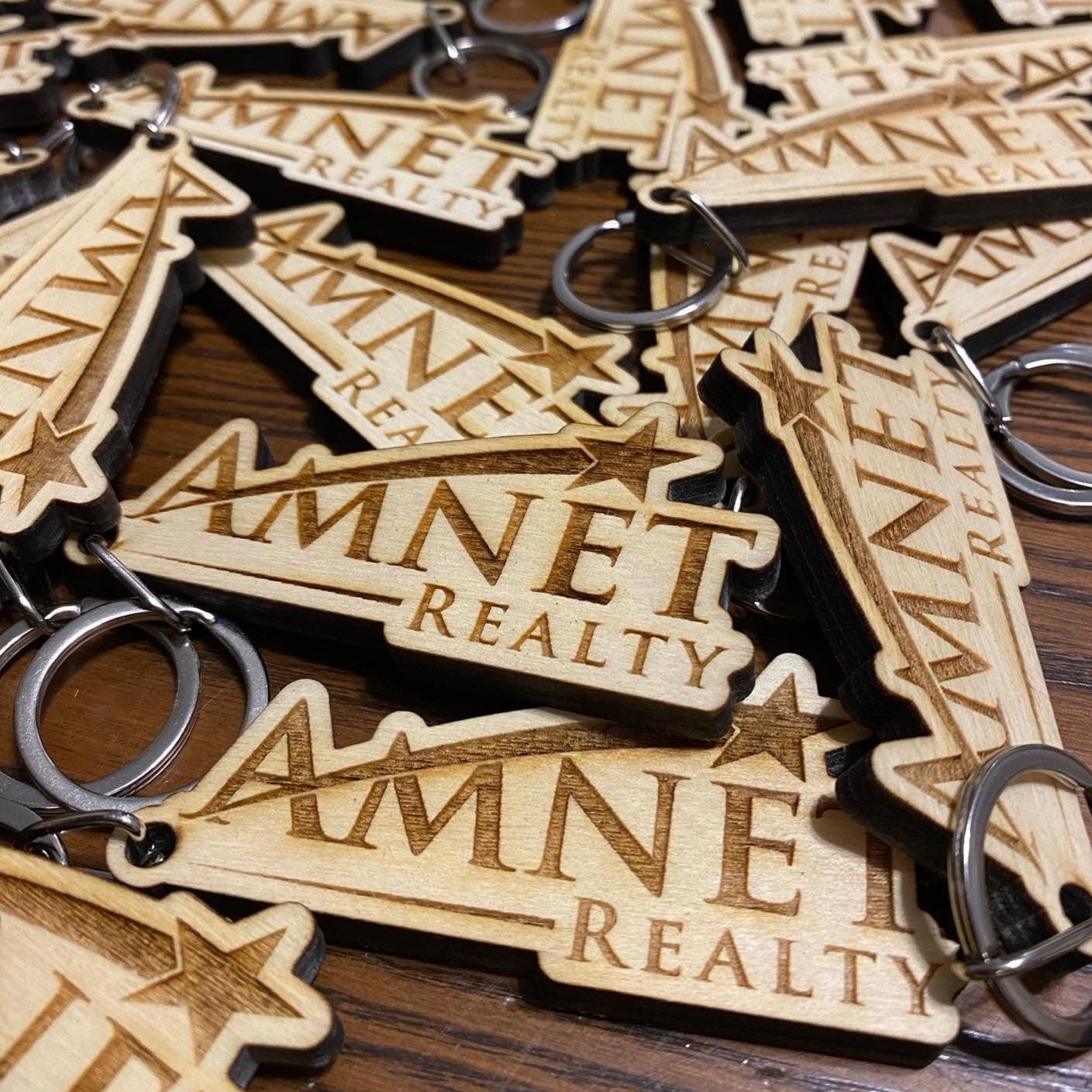 Custom logo engraved wood keychain made from baltic birch plywood with a stainless steel key ring.