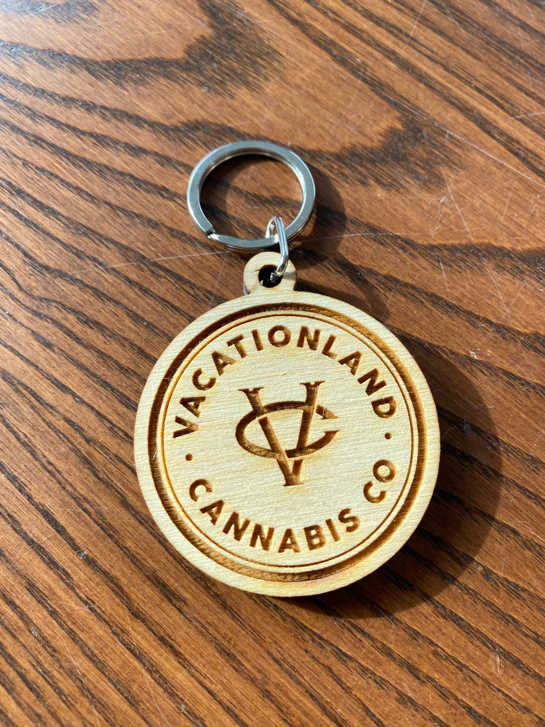 Custom logo engraved wood keychain made from baltic birch plywood with a stainless steel key ring.