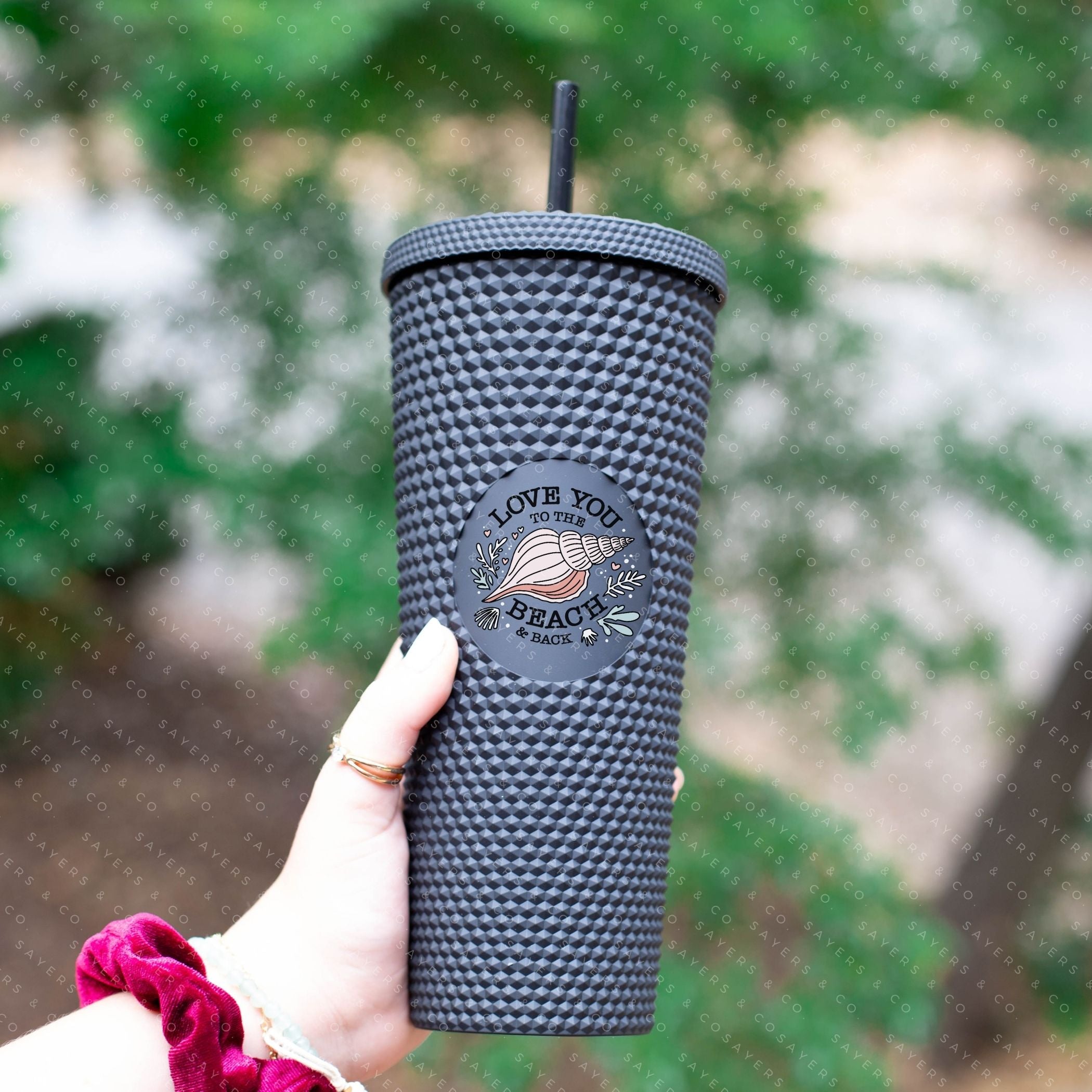 Custom studded 24oz double walled tumbler featuring a beach-themed design with seashells and waves, perfect for summer drinks.