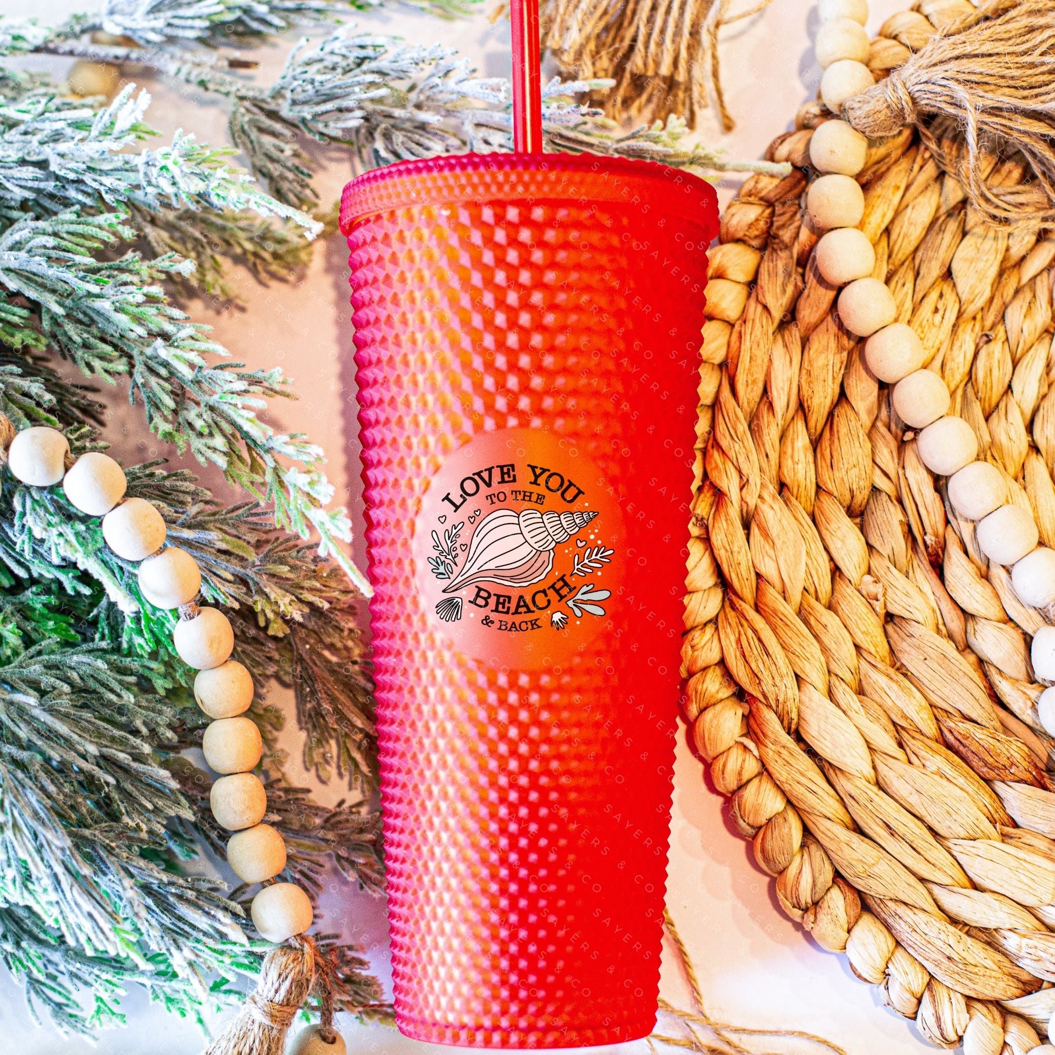 Custom studded 24oz double walled tumbler featuring a beach-themed design with seashells and waves, perfect for summer drinks.