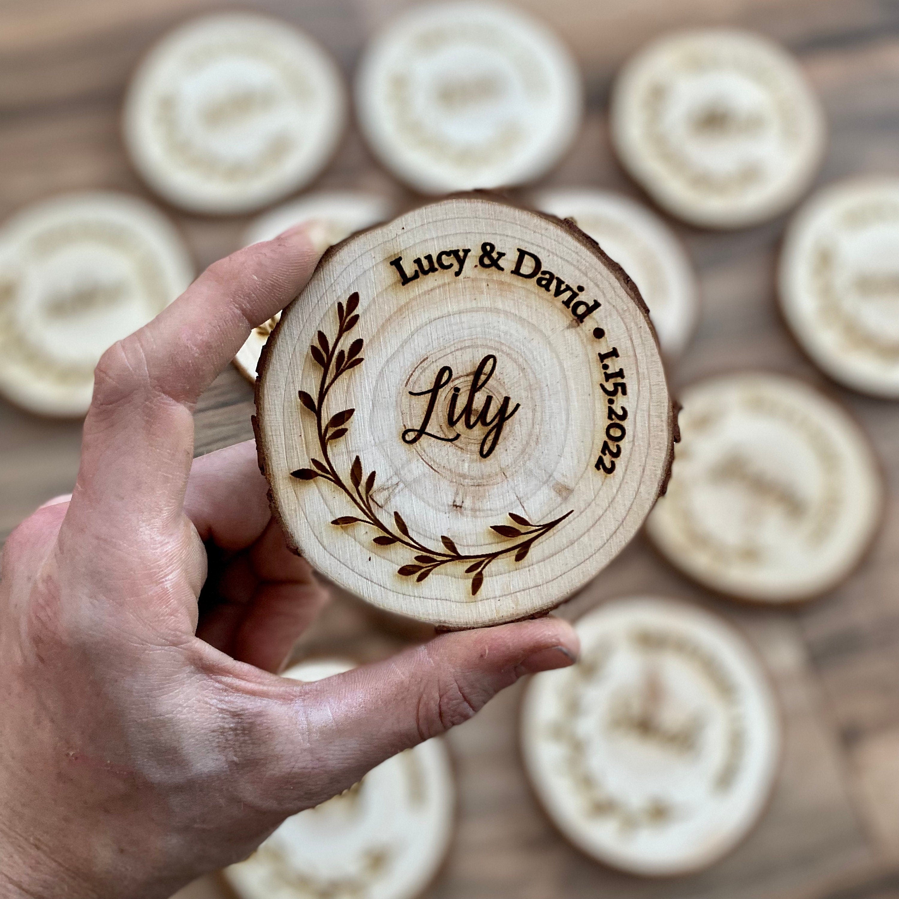 Personalized wood slice coasters with engraved names and wedding date, showcasing rustic charm.