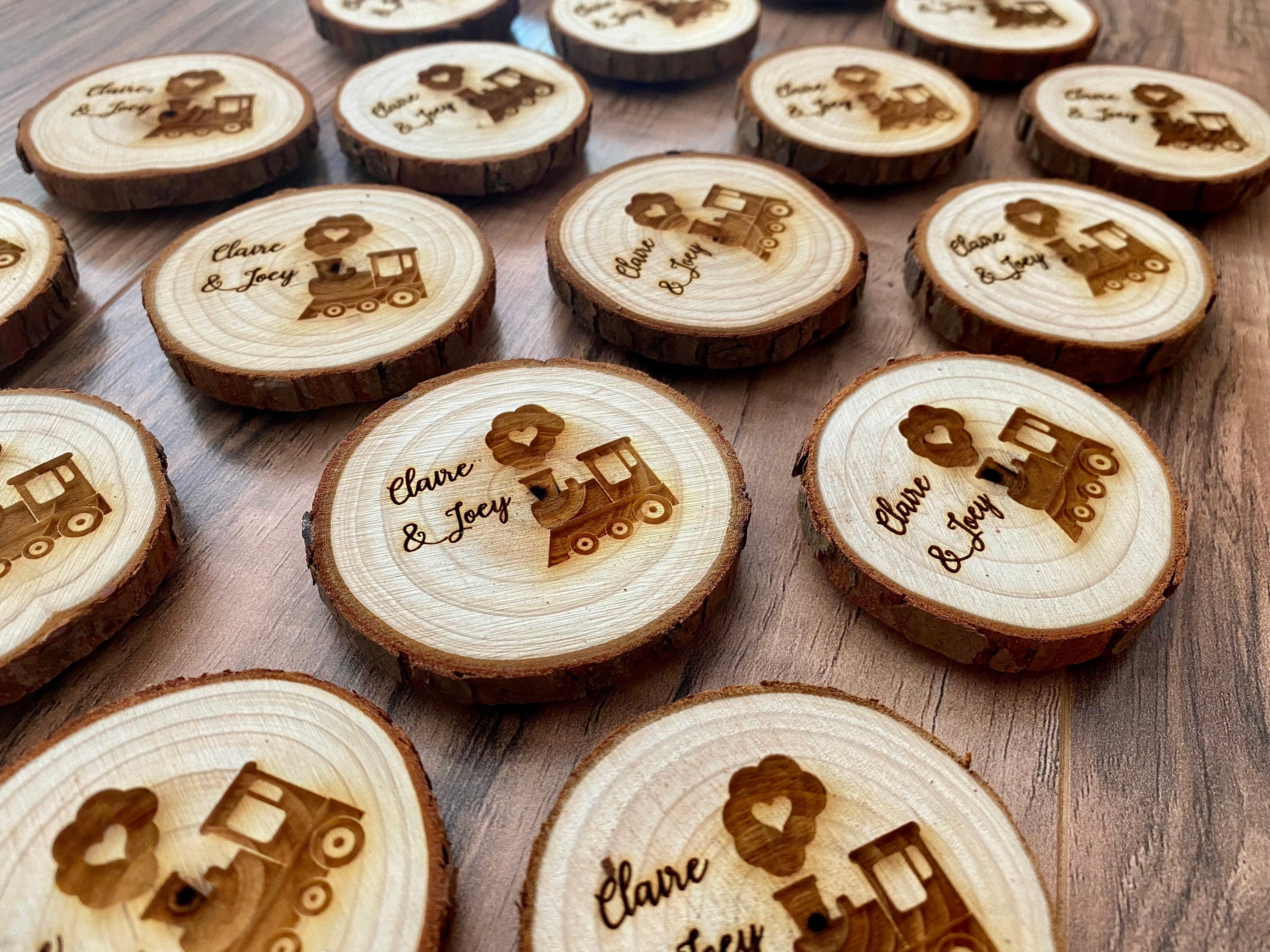 Personalized engraved wood slice birthday party favor featuring a cute train image and custom names, with a magnet on the back.