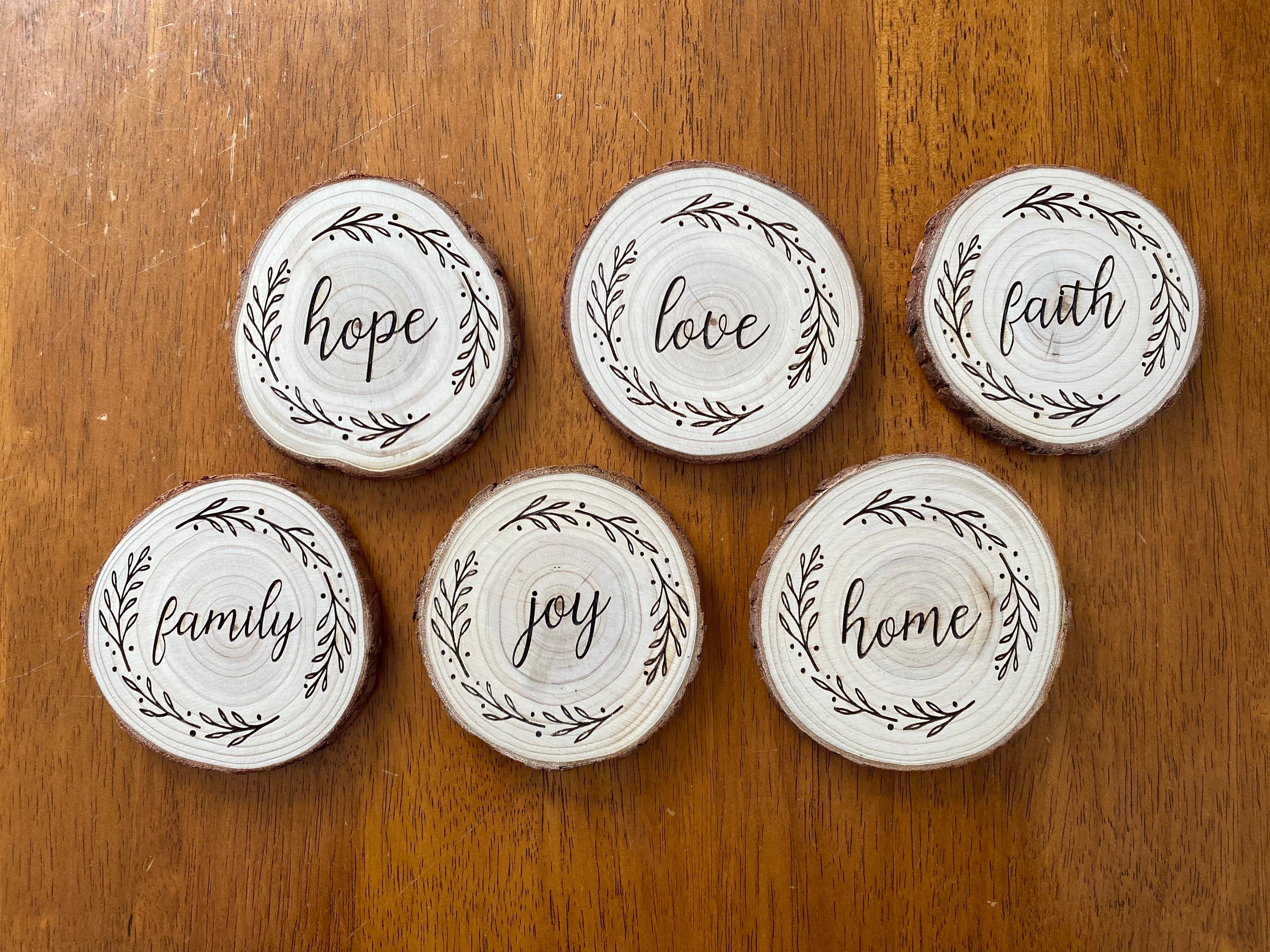 A beautifully crafted set of wood coasters engraved with the words Faith, Hope, and Love, showcasing rustic charm and natural wood grain.
