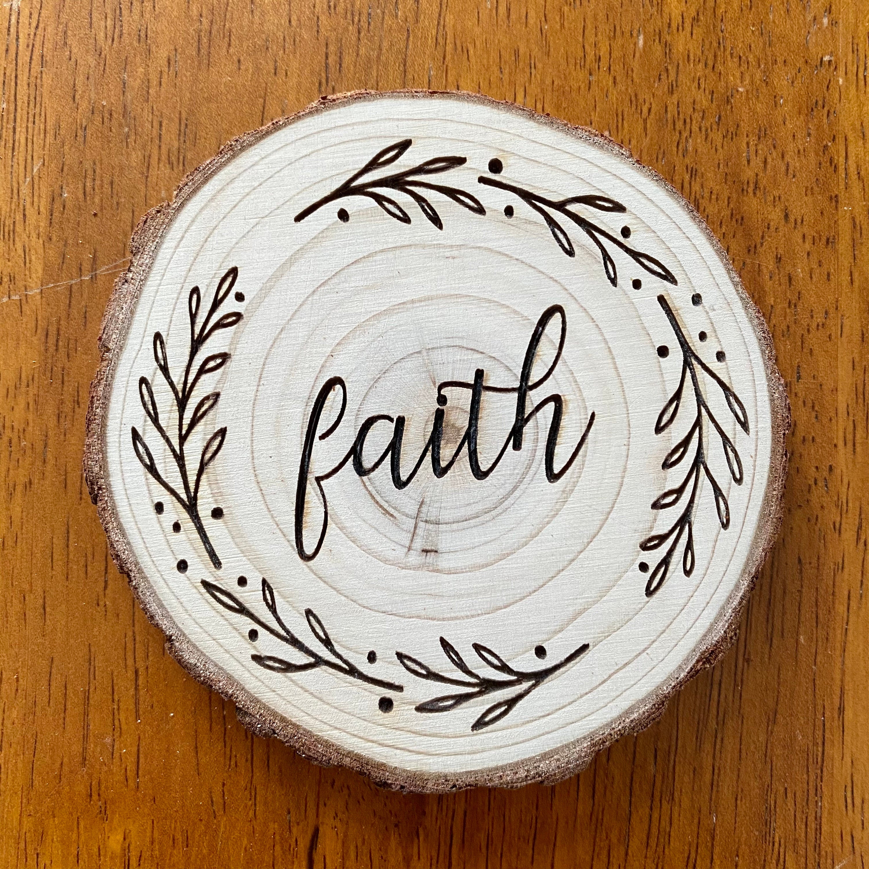 A beautifully crafted set of wood coasters engraved with the words Faith, Hope, and Love, showcasing rustic charm and natural wood grain.