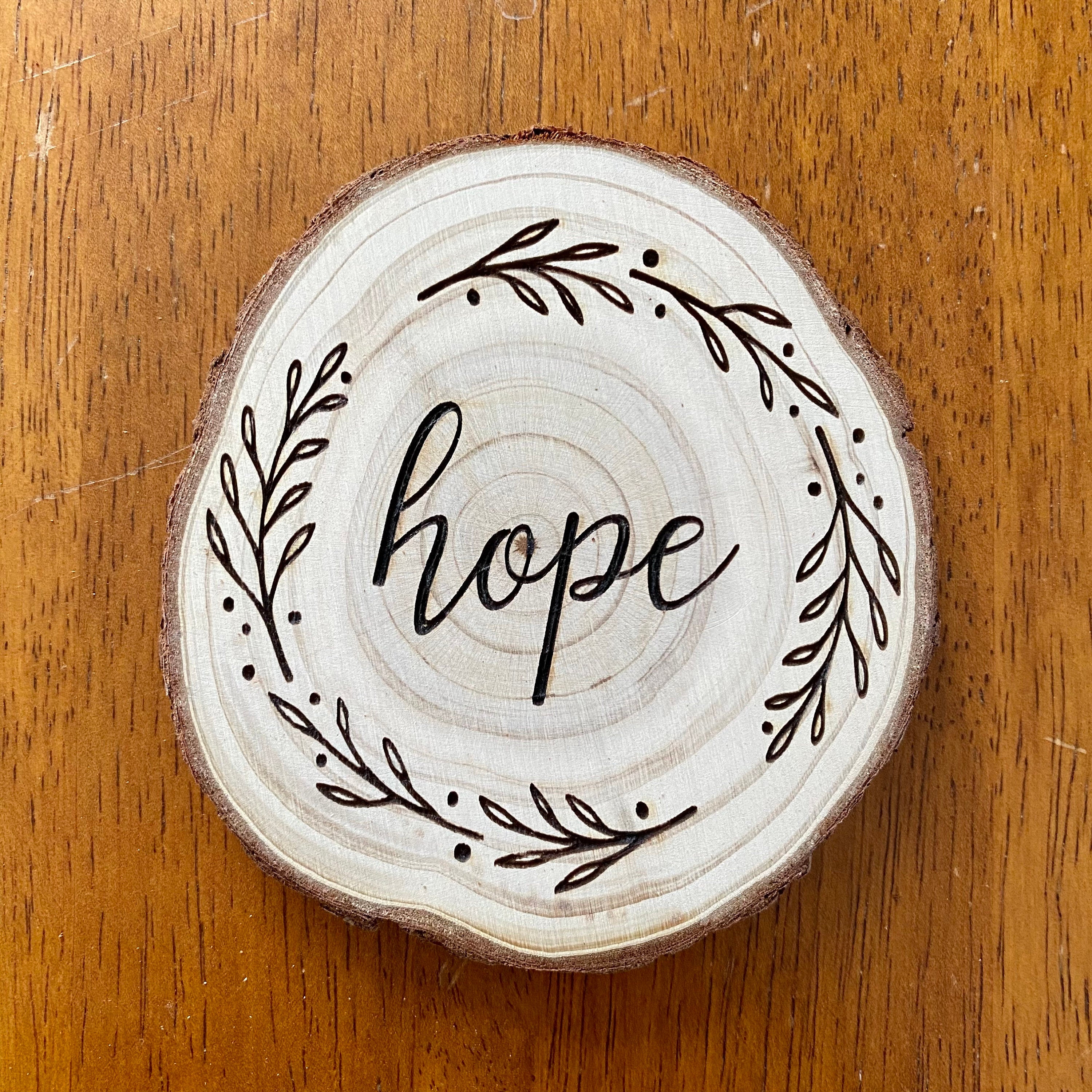 A beautifully crafted set of wood coasters engraved with the words Faith, Hope, and Love, showcasing rustic charm and natural wood grain.