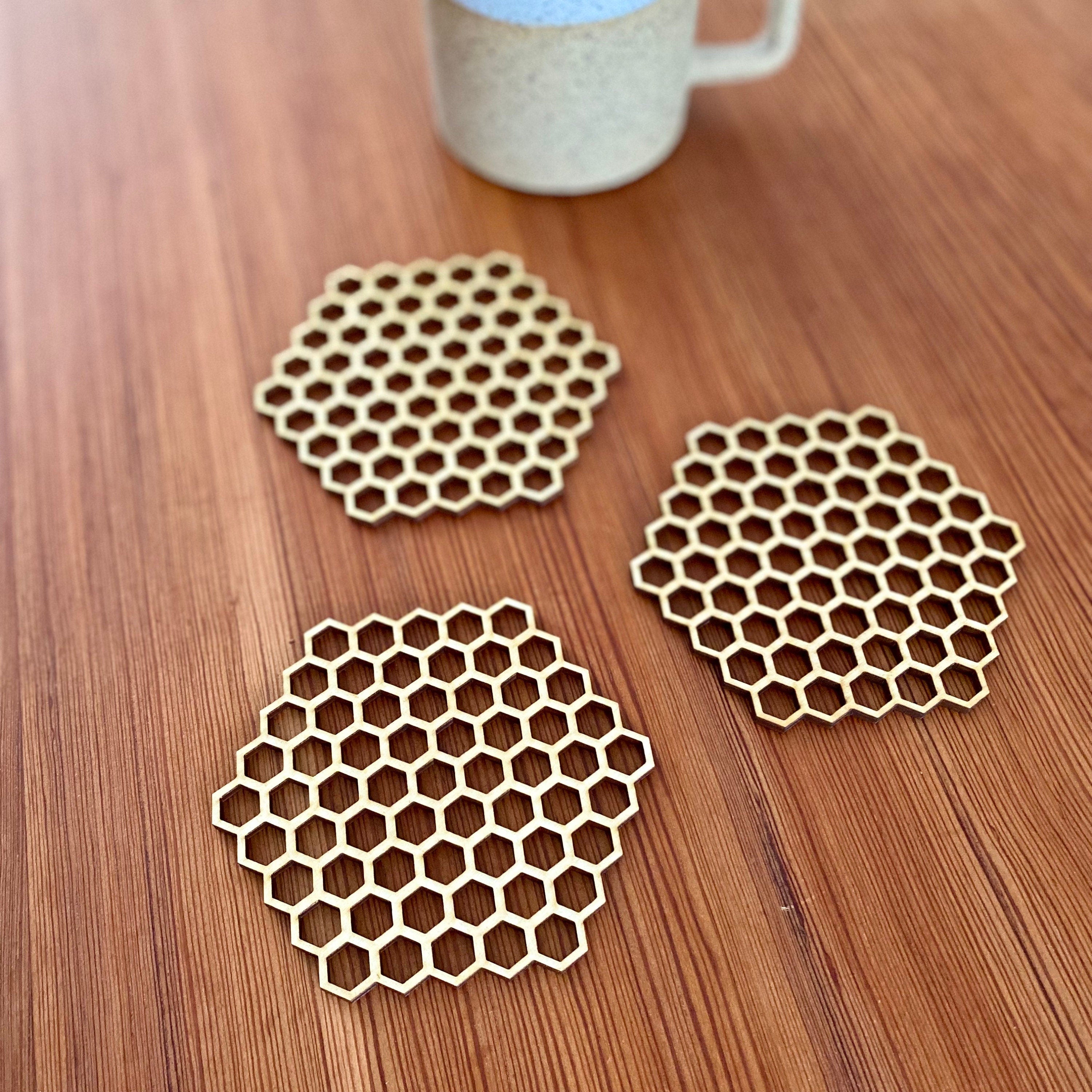 A set of honeycomb laser cut wood coasters made from high-quality birch plywood, showcasing a unique hexagonal design.