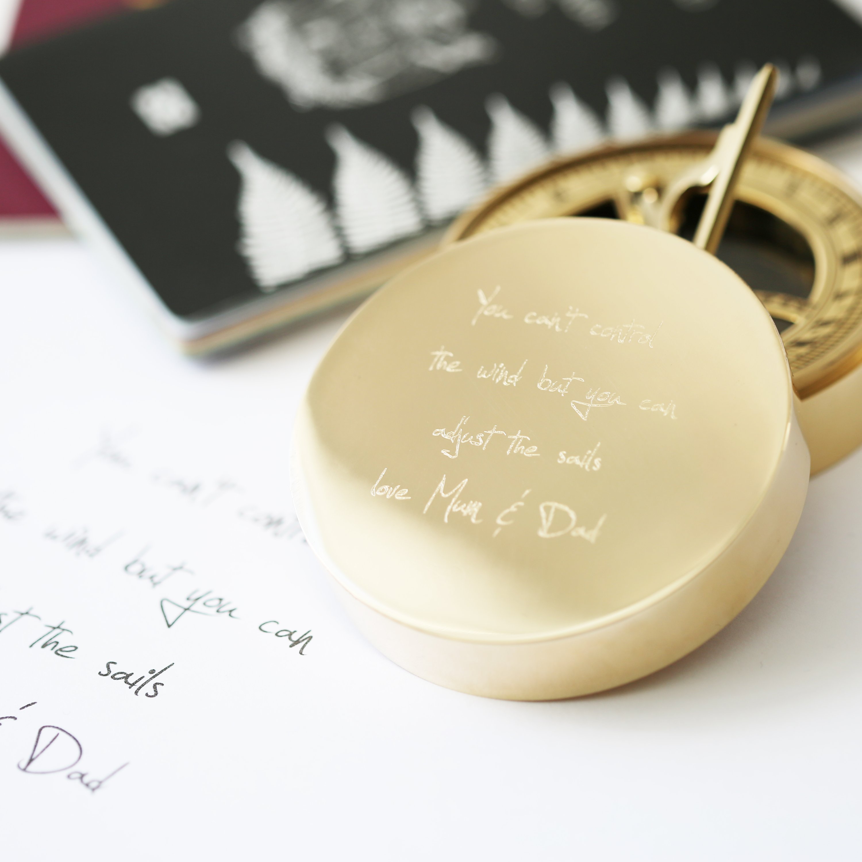 Personalised brass nautical sundial compass with custom handwriting engraving, complete with protective pouch and gift box.