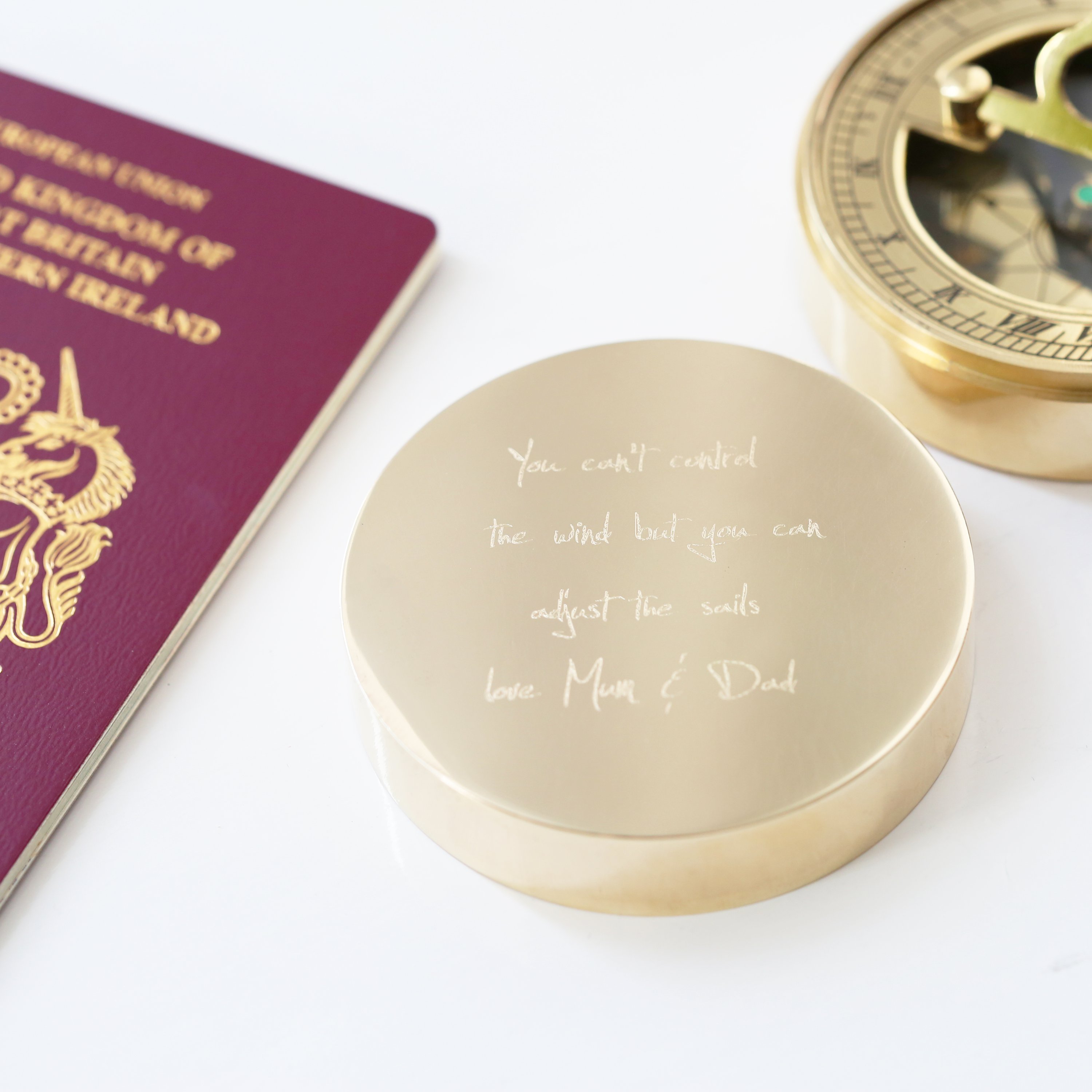 Personalised brass nautical sundial compass with custom handwriting engraving, complete with protective pouch and gift box.