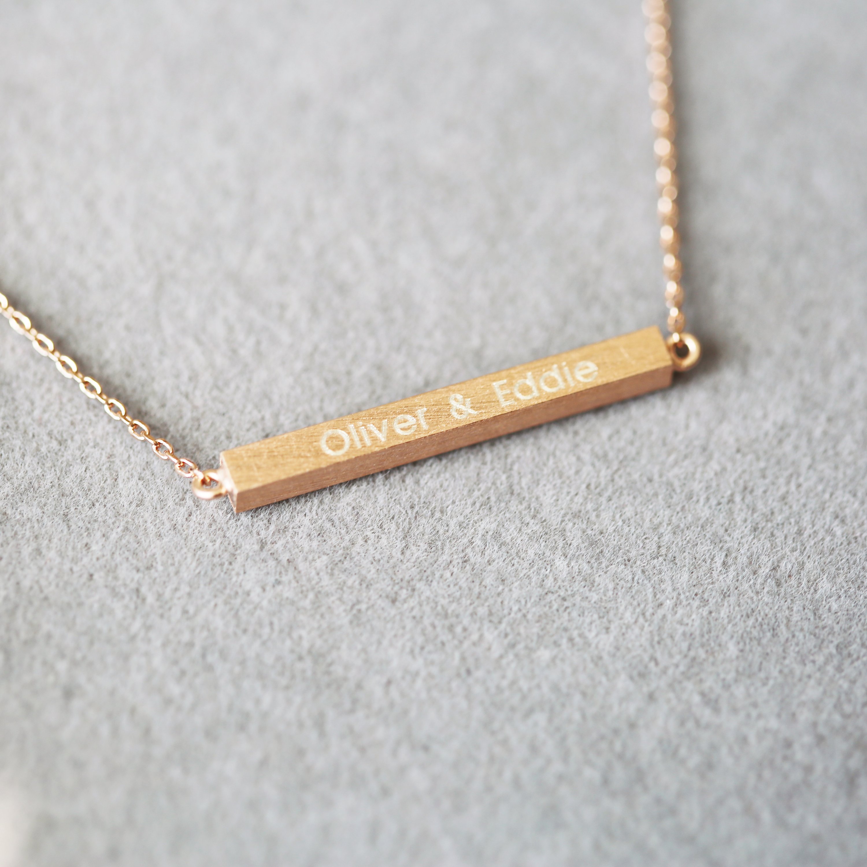A stunning personalised horizontal necklace in silver, gold, and rose gold, featuring custom engraving options and an adjustable chain.