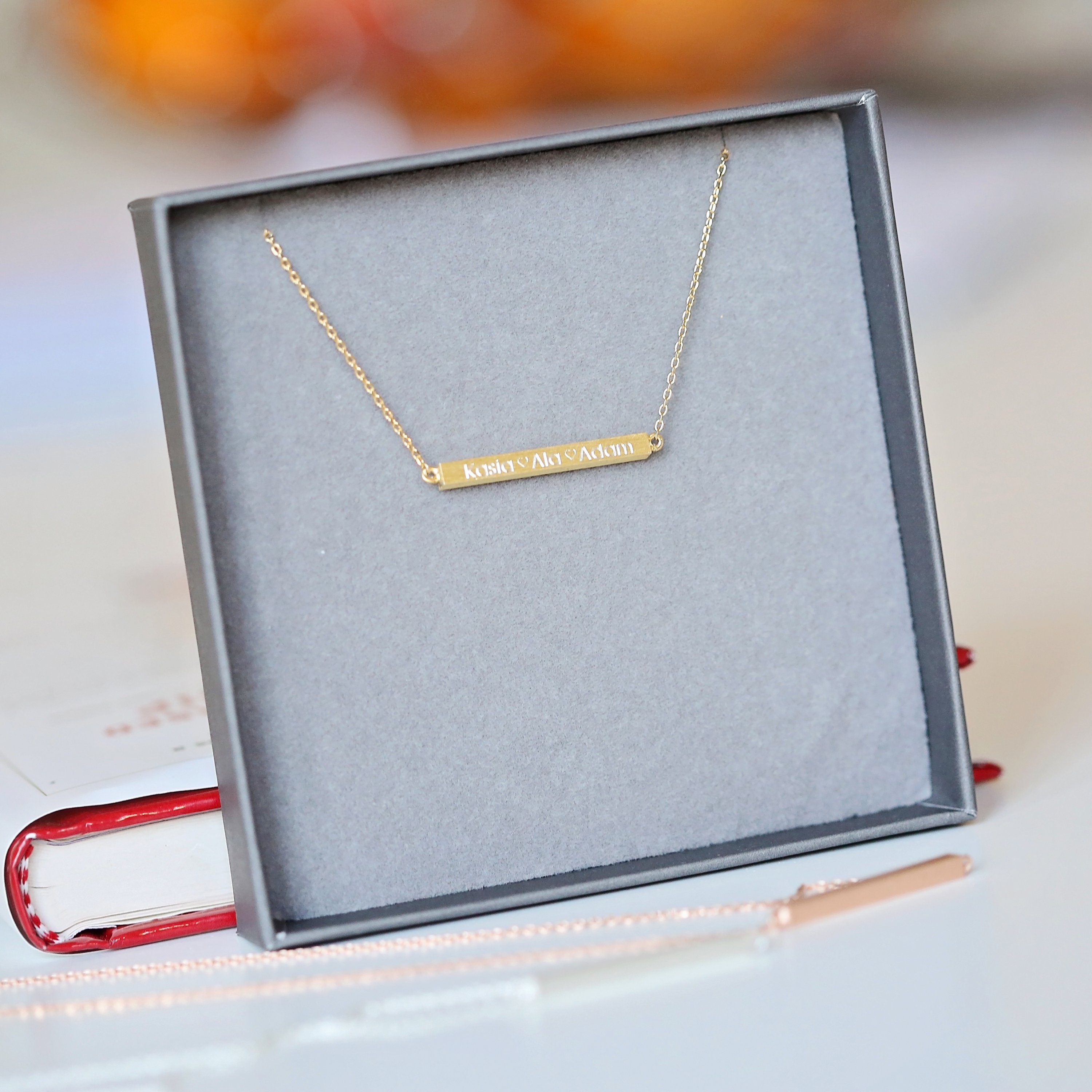 A stunning personalised horizontal necklace in silver, gold, and rose gold, featuring custom engraving options and an adjustable chain.