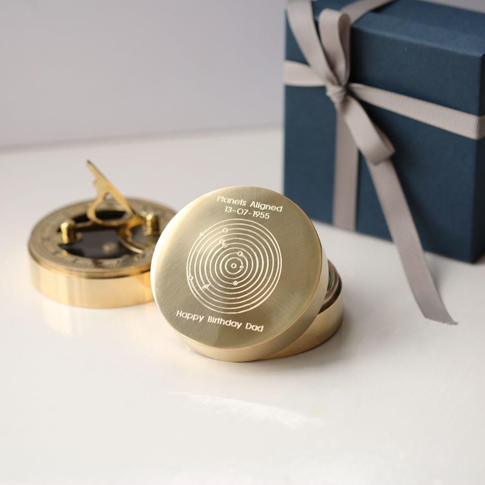 Planets Aligned Nautical Sundial Compass with engraved planetary alignment, brass finish, and protective pouch.