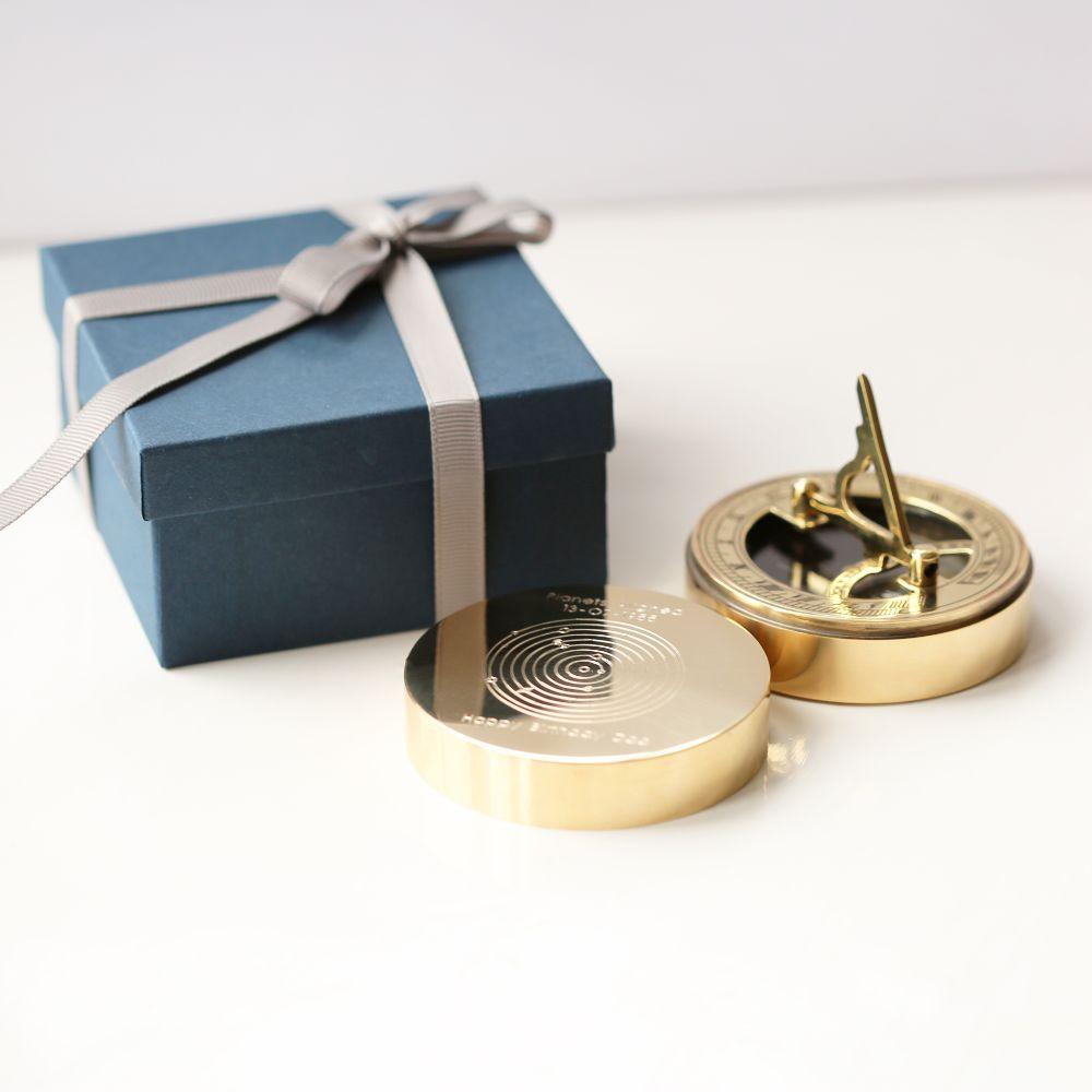 Planets Aligned Nautical Sundial Compass with engraved planetary alignment, brass finish, and protective pouch.