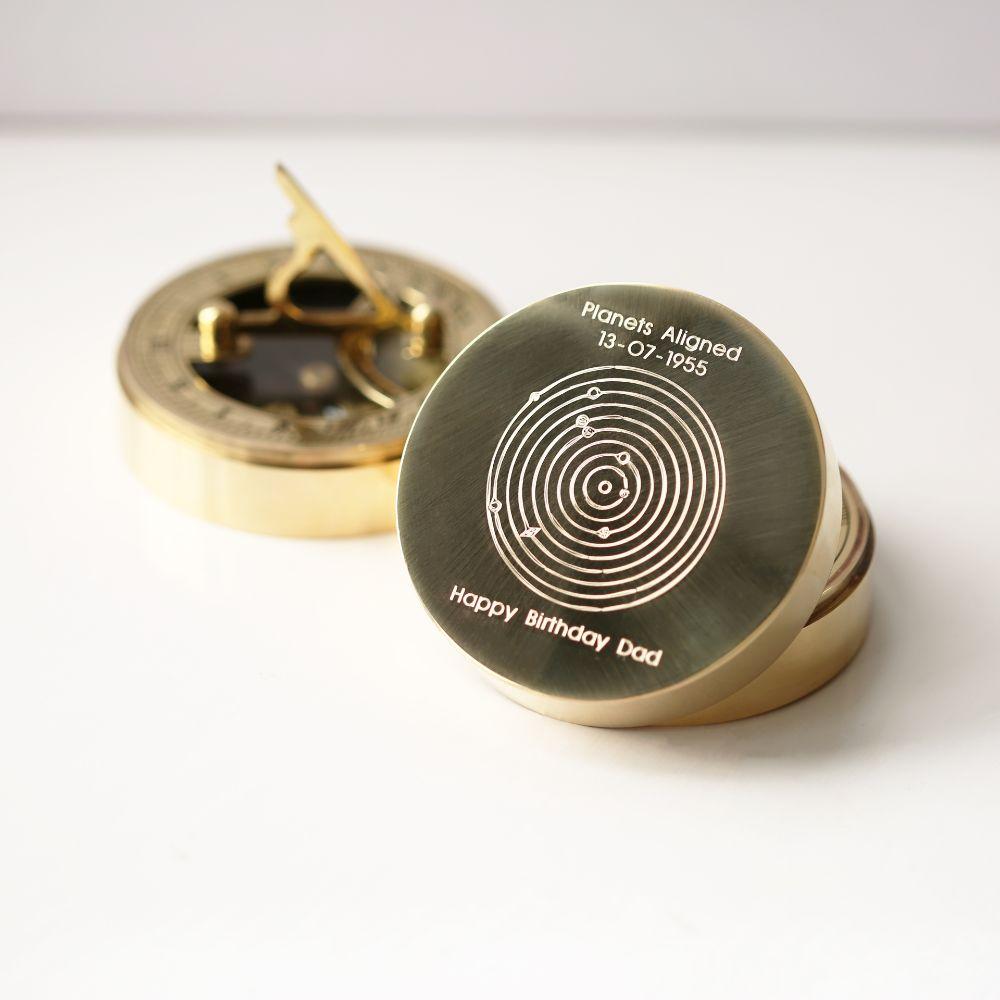 Planets Aligned Nautical Sundial Compass with engraved planetary alignment, brass finish, and protective pouch.