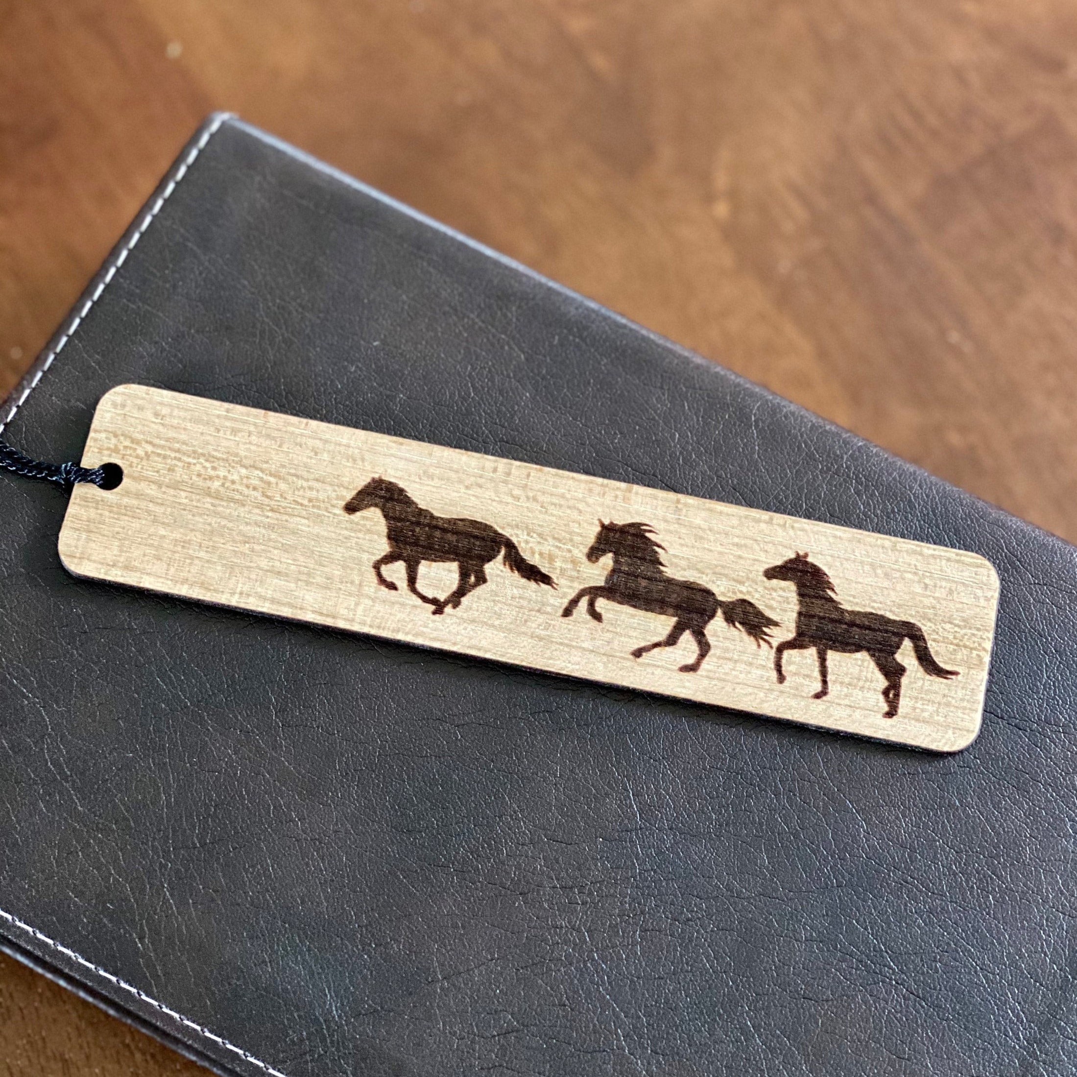 Engraved wood bookmark featuring galloping horses, made of cherry hardwood with a colorful tassel.