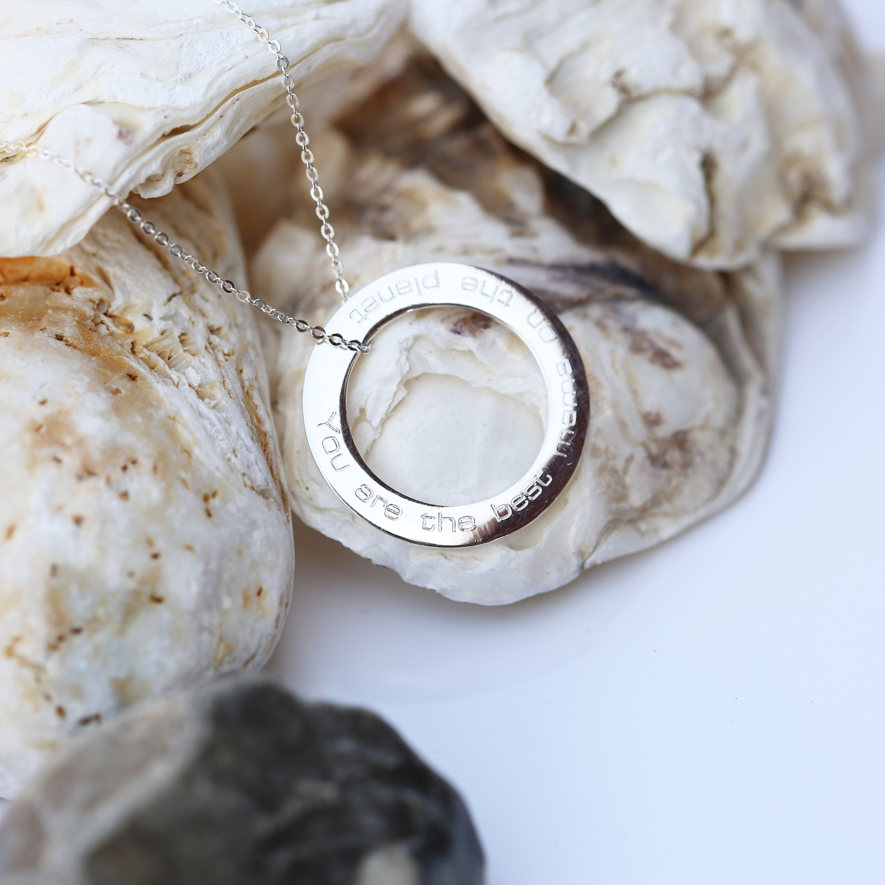 A stunning sterling silver halo necklace with an engraved pendant, elegantly displayed in a gift box.