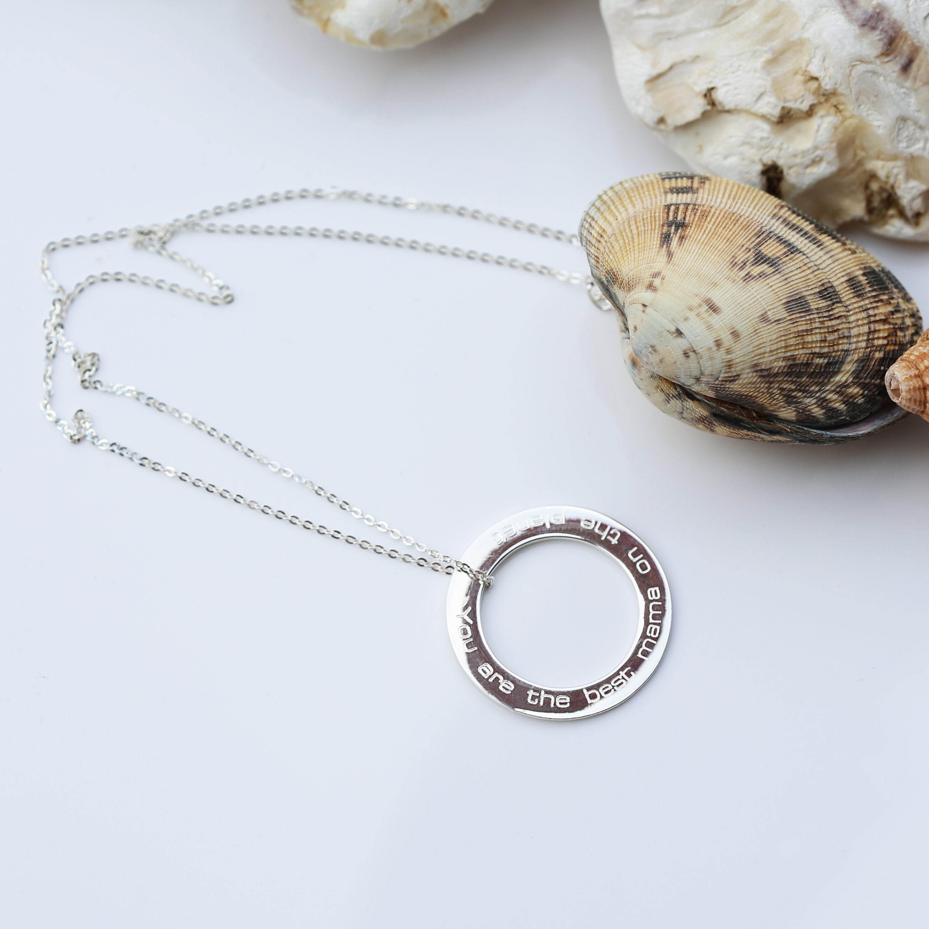 A stunning sterling silver halo necklace with an engraved pendant, elegantly displayed in a gift box.