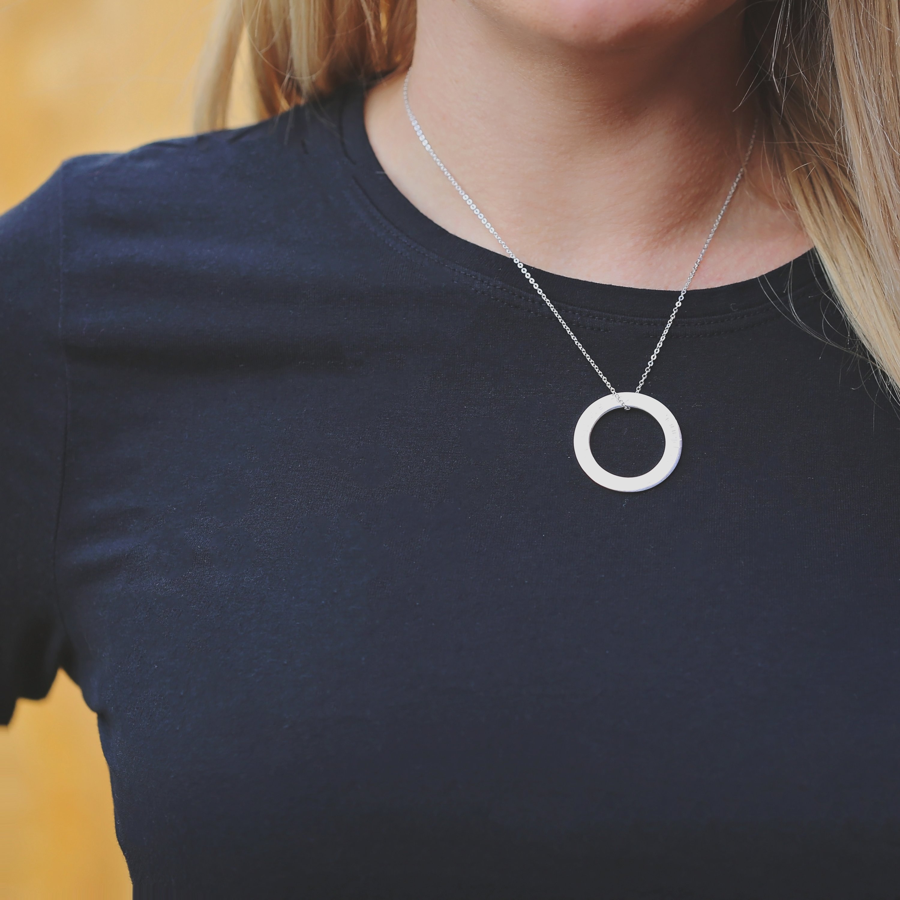 A stunning sterling silver halo necklace with an engraved pendant, elegantly displayed in a gift box.