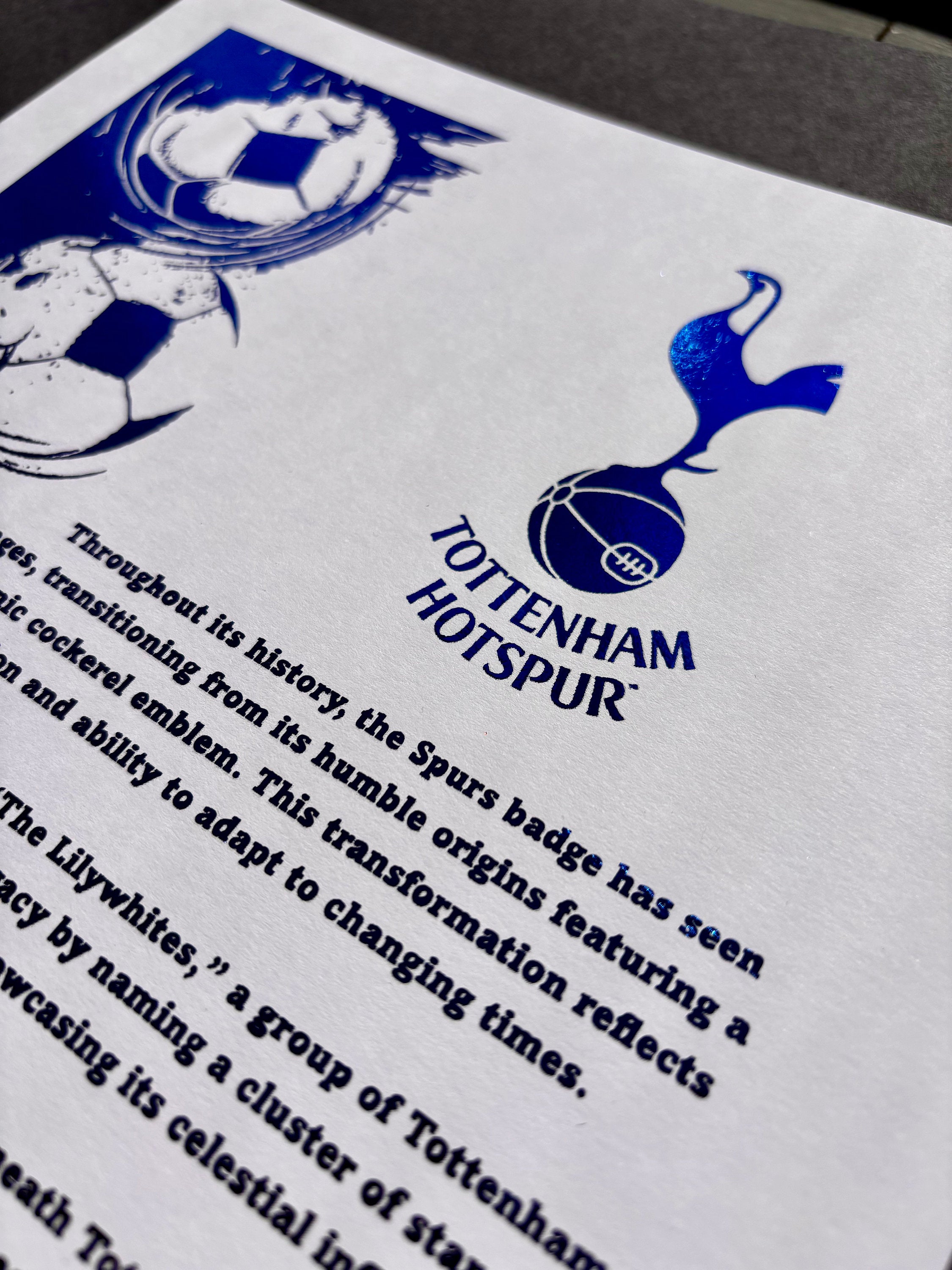 A4 foil print featuring the Tottenham Hotspur logo in blue foil, showcasing the club's rich history and tradition.