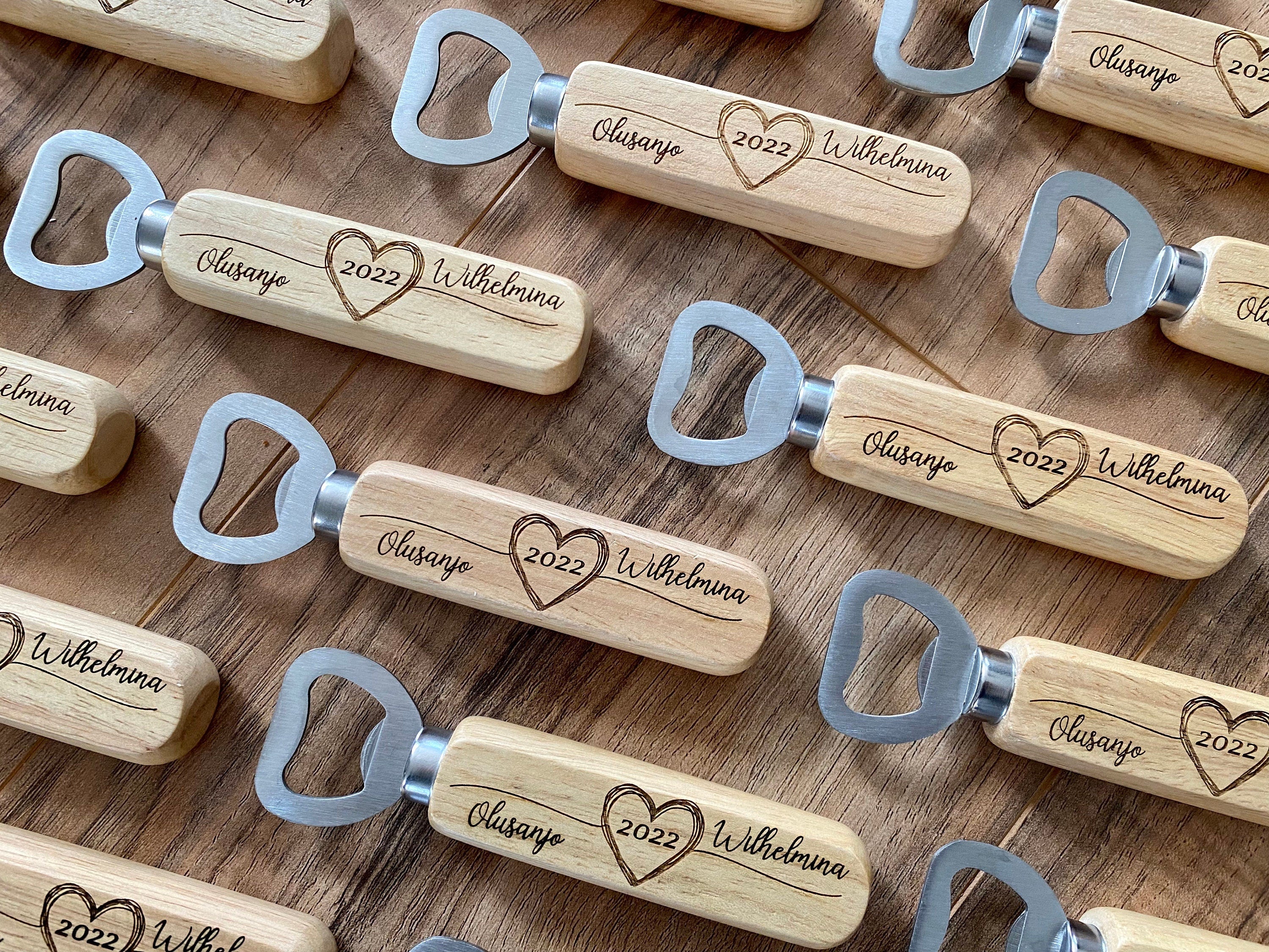 Personalized wooden bottle opener with engraved names and heart design, perfect for rustic wedding favors.