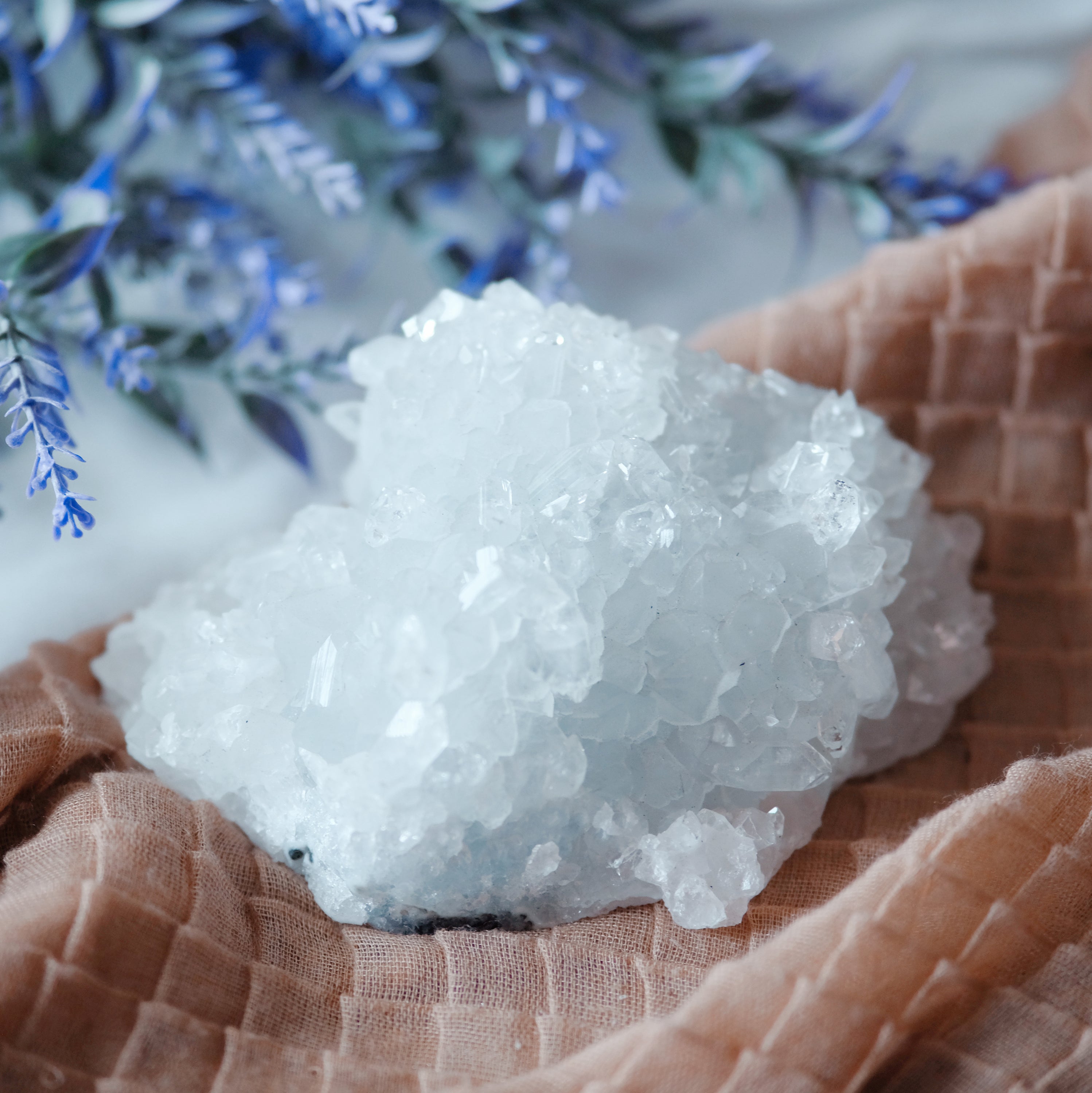 A beautiful cluster of Apophyllite crystals showcasing their unique structure and clarity, reflecting light in various shades of green and white.
