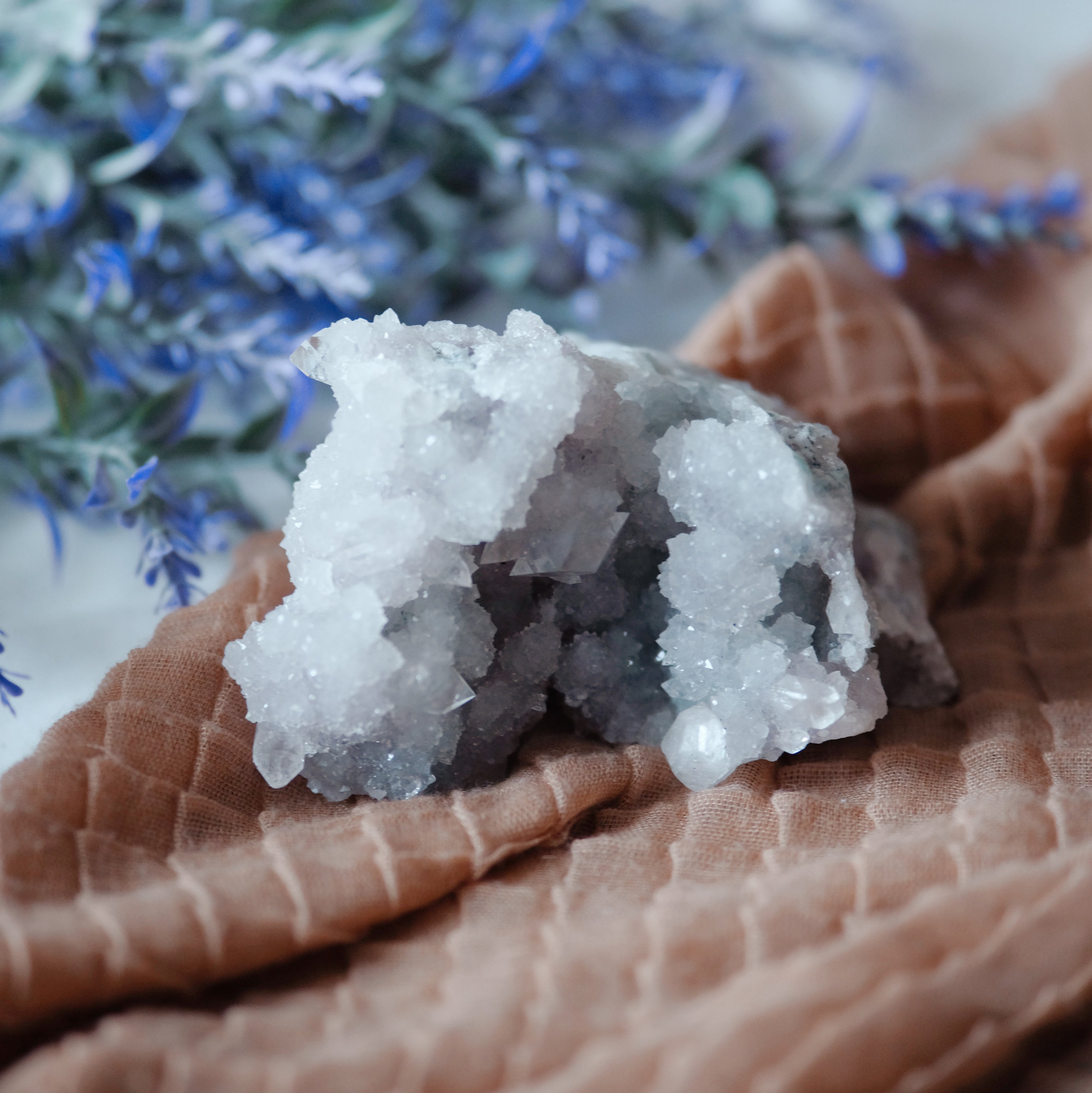 A beautiful cluster of Apophyllite crystals showcasing their unique structure and clarity, reflecting light in various shades of green and white.