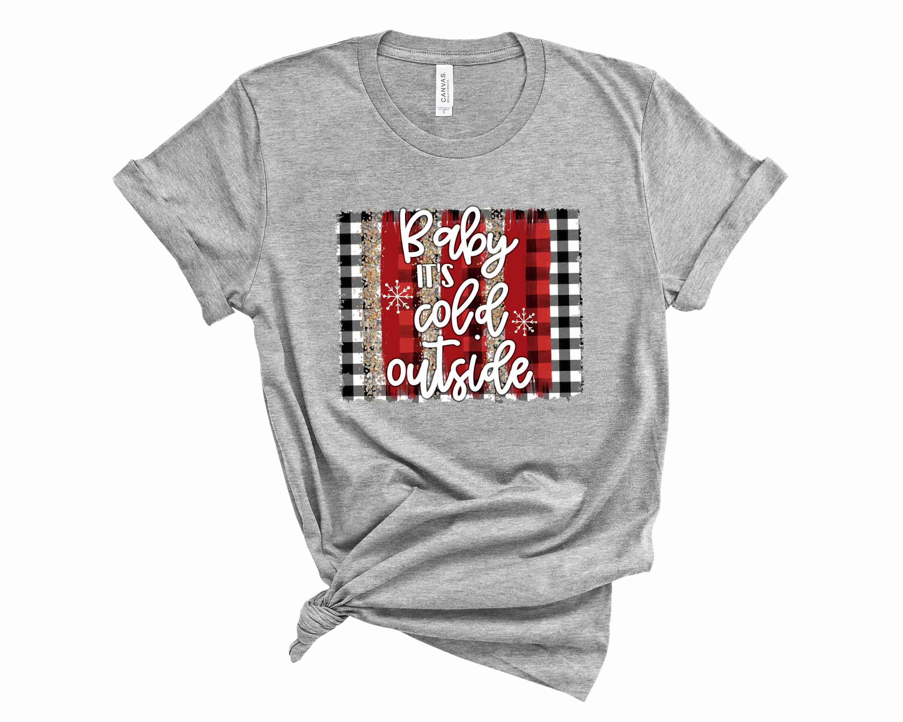 A cozy unisex graphic tee featuring the phrase 'Baby It's Cold Outside' in a stylish plaid design, perfect for winter wear.