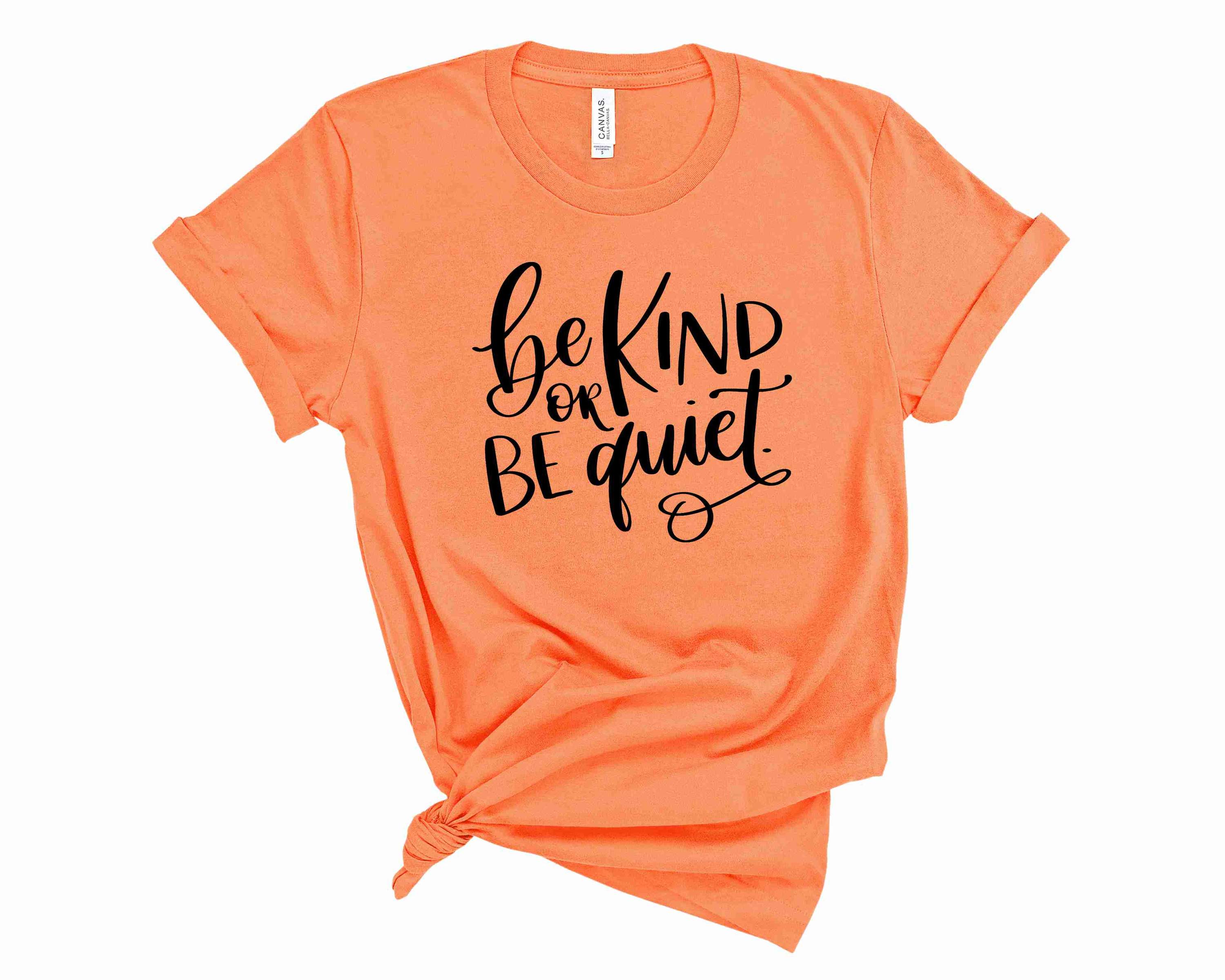 A unisex graphic tee featuring the phrase 'Be Kind or Be Quiet' in bold lettering, showcasing a stylish and comfortable design.