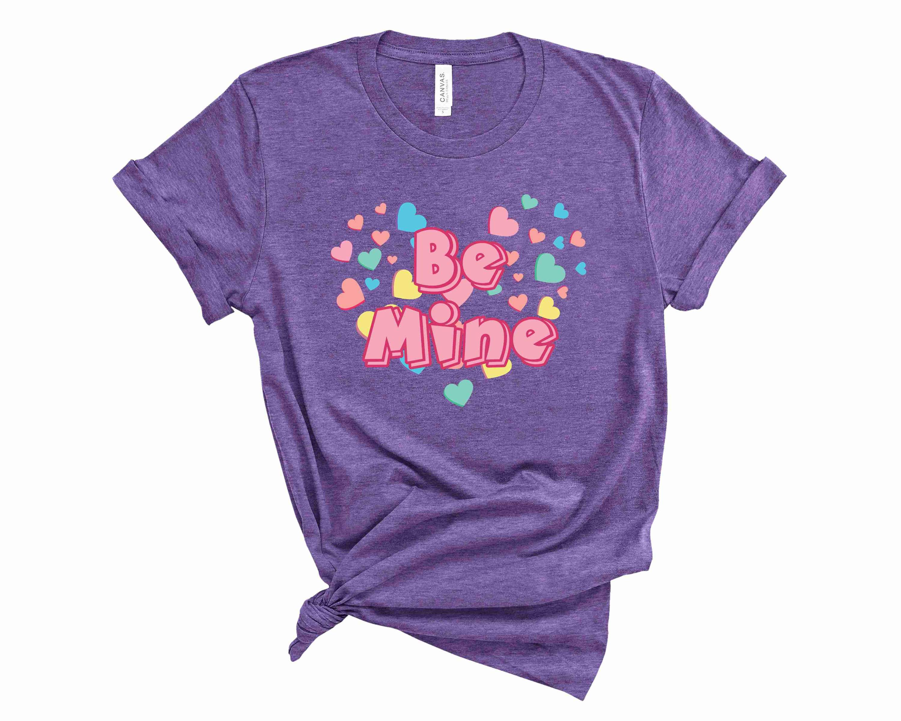 Be Mine Candy Hearts Graphic Tee featuring colorful heart designs on a soft unisex t-shirt.
