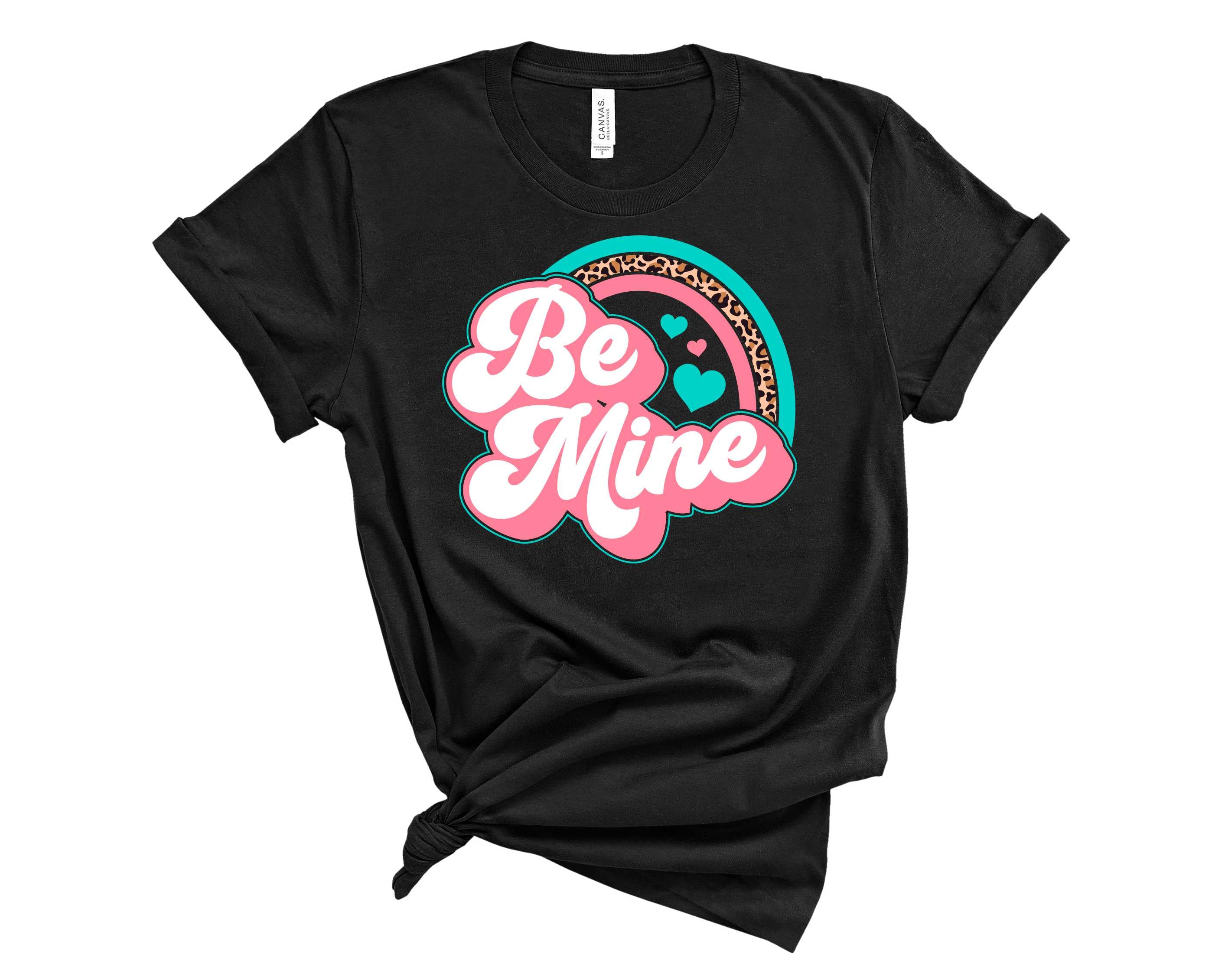 Be Mine Leopard Rainbow graphic tee featuring vibrant colors and a playful leopard print design, suitable for unisex wear.