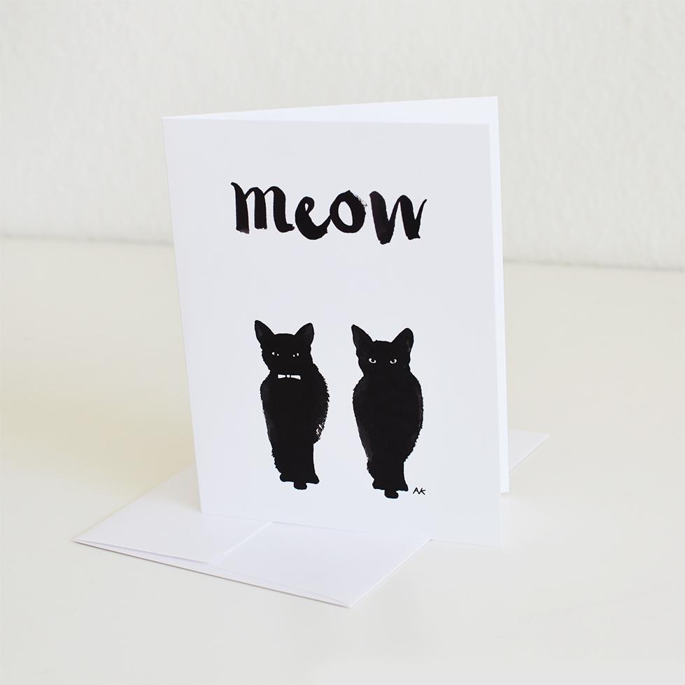 A beautifully illustrated black cat on a greeting card, featuring a crystal or orange metallic envelope.
