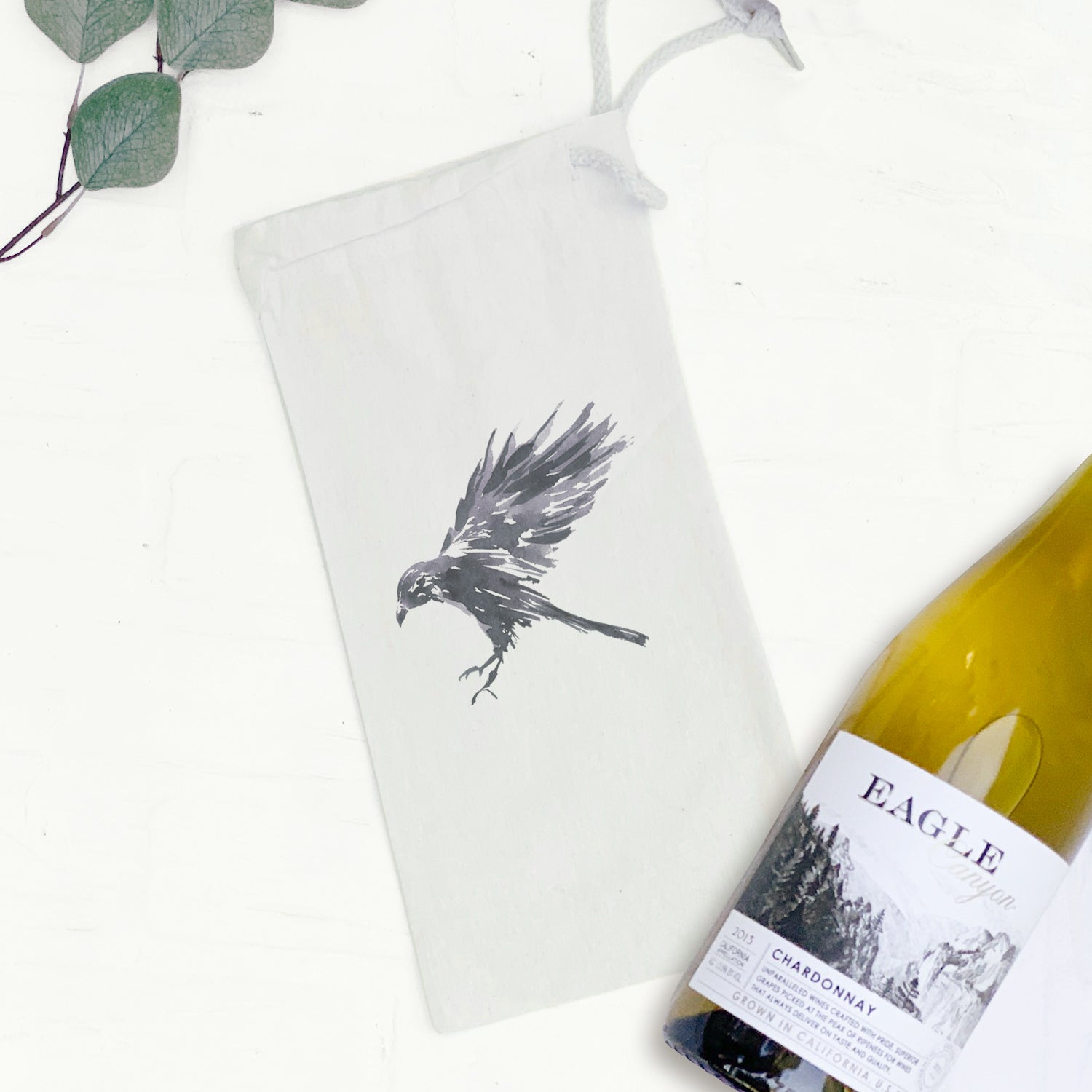 Black Raven Canvas Wine Bag featuring a stylish raven design, made from durable cotton canvas with a drawstring closure.