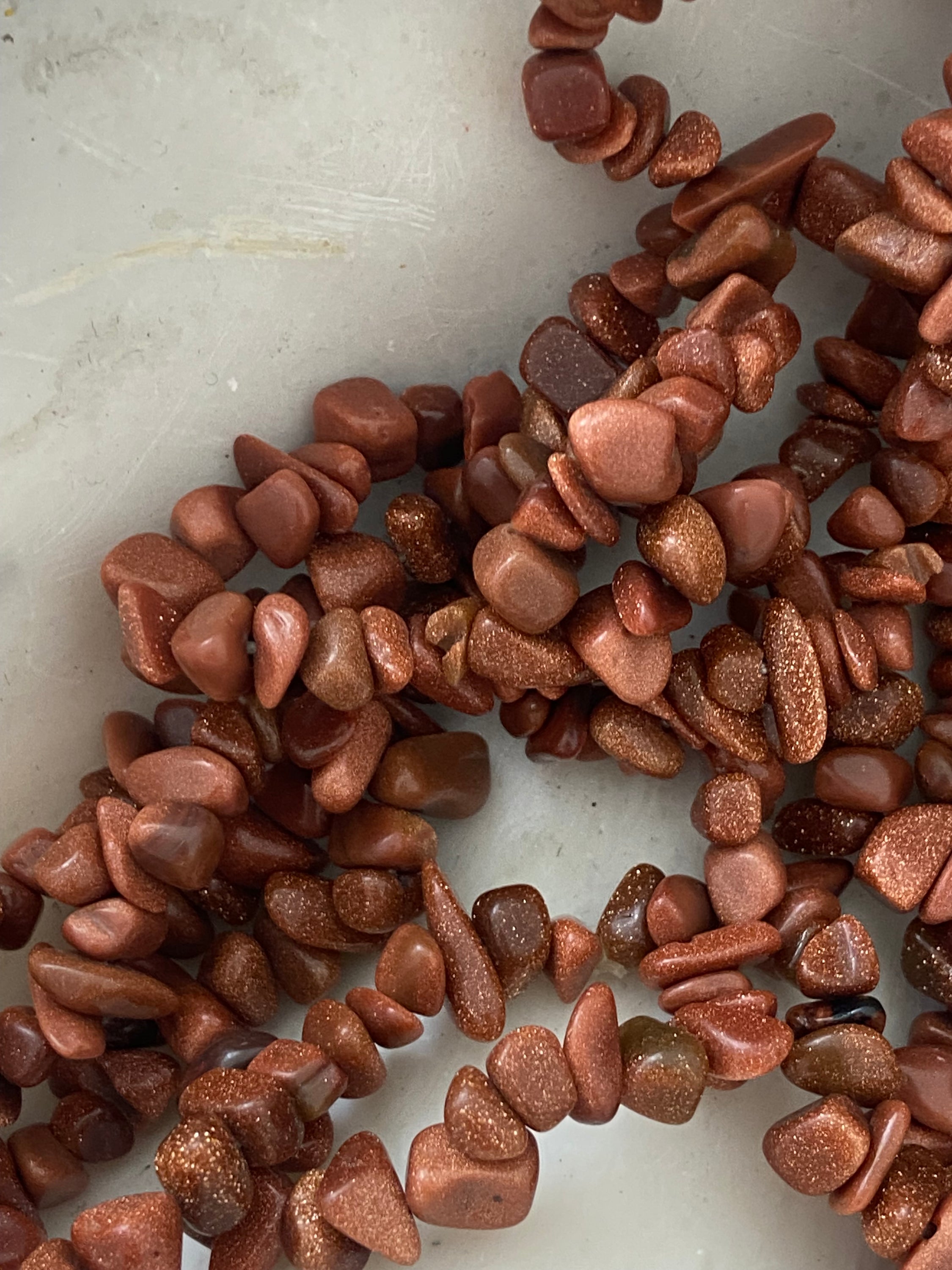 Bracelet en pierre de soleil avec paillettes de cuivre, symbolisant la joie et la vitalité, sur fond neutre.