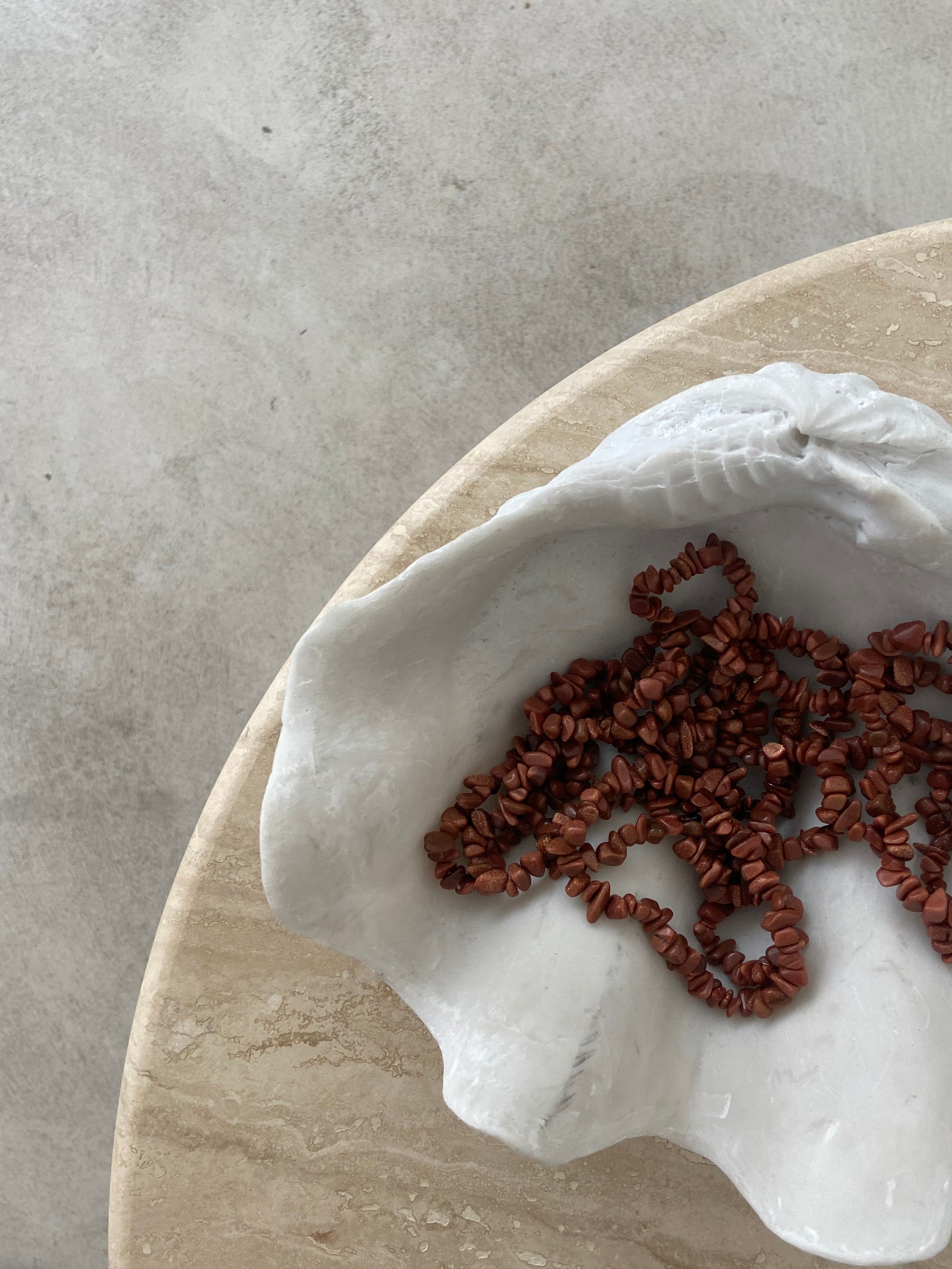 Bracelet en pierre de soleil avec paillettes de cuivre, symbolisant la joie et la vitalité, sur fond neutre.