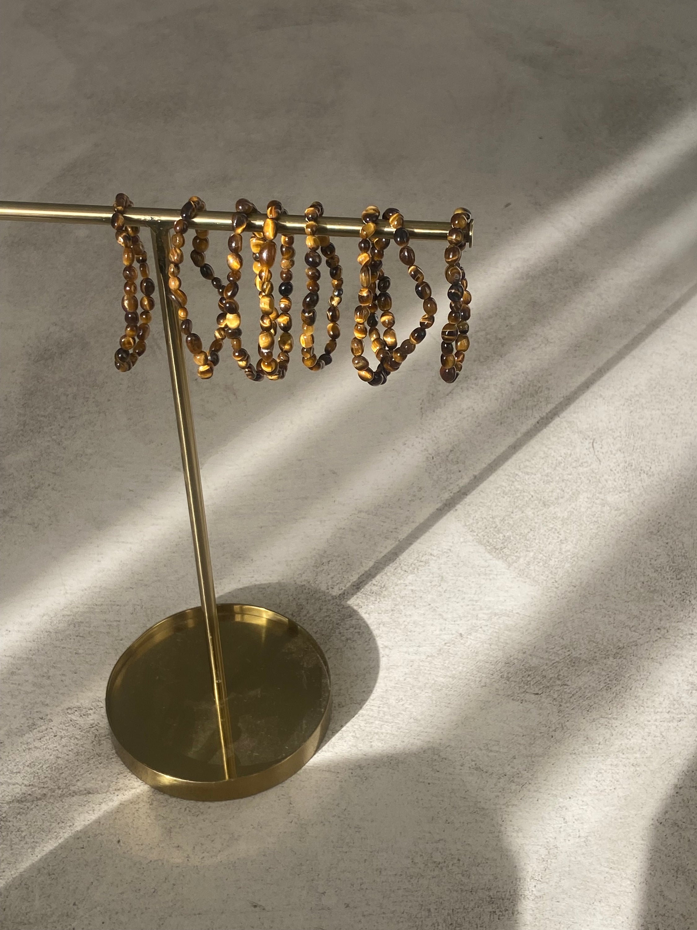 Bracelet Galets en œil de tigre, symbole de force et de protection, avec des galets polis et un design élégant.