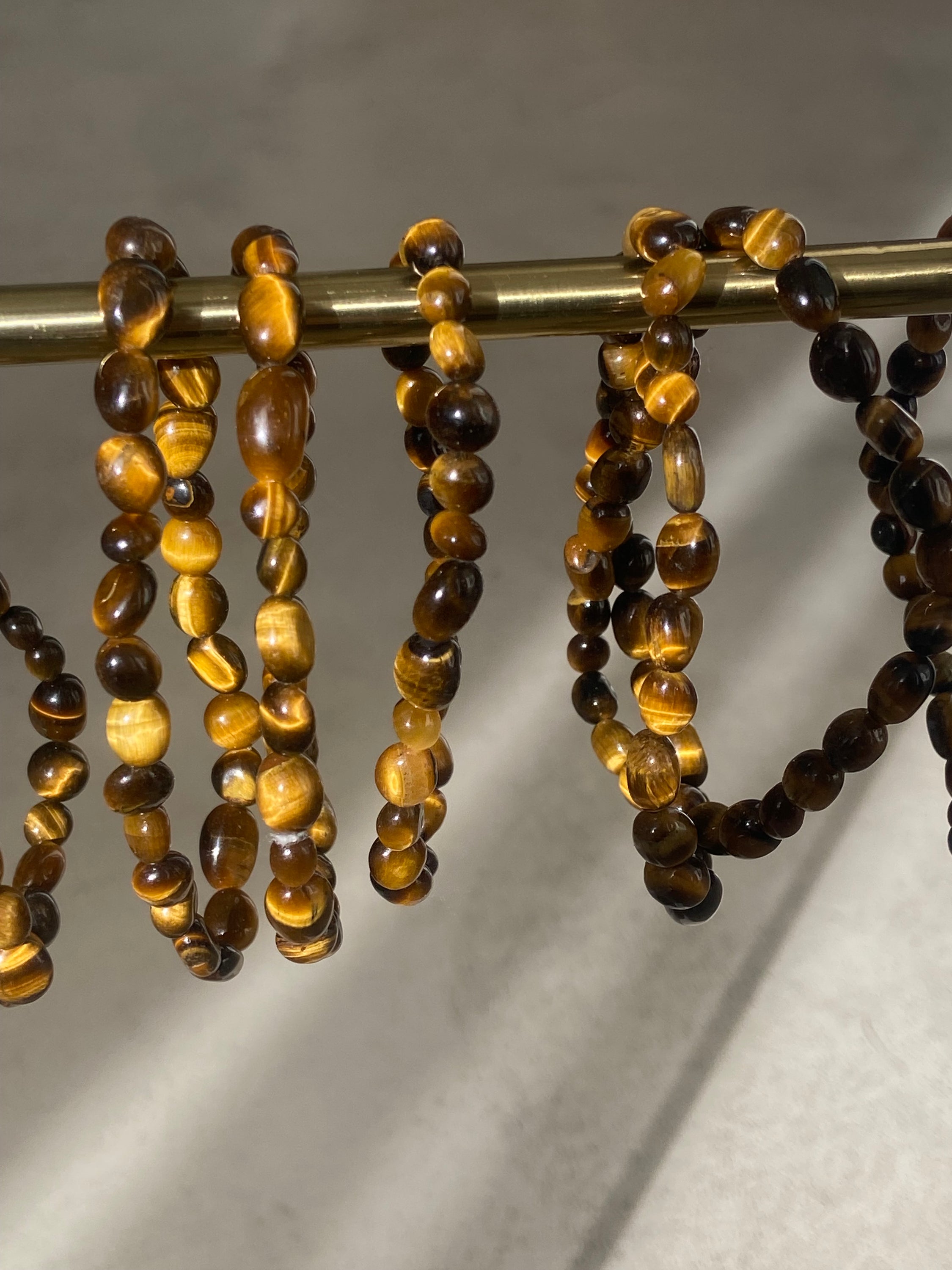 Bracelet Galets en œil de tigre, symbole de force et de protection, avec des galets polis et un design élégant.