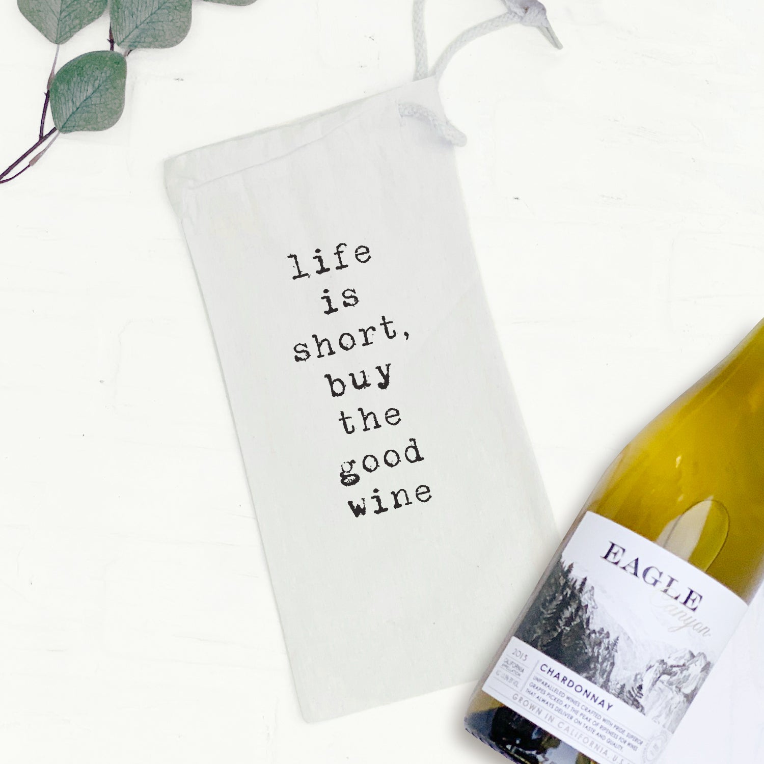 A stylish canvas wine bag in natural cotton, featuring a matching drawstring closure, designed to hold a standard 750mL wine bottle.