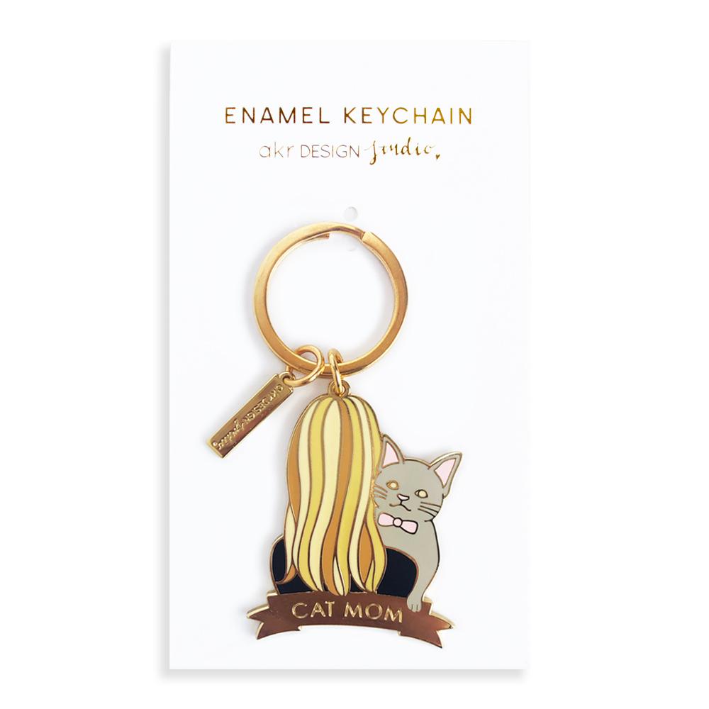 A stylish blonde cat keychain made of hard enamel, featuring a cute design and attached to a keyring.