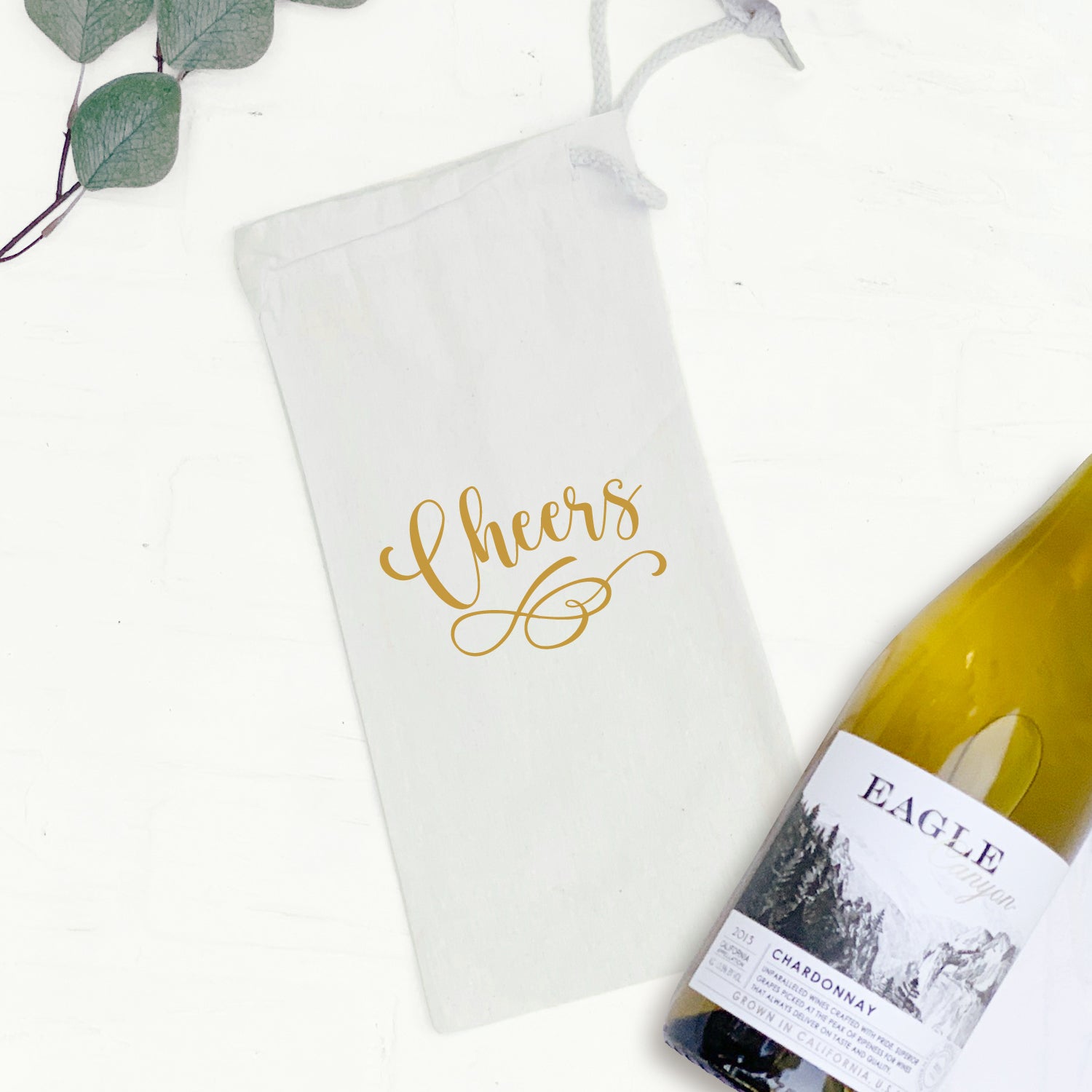 A stylish Champagne Cheers canvas wine bag with a matching drawstring closure, designed to hold a standard 750mL wine bottle.