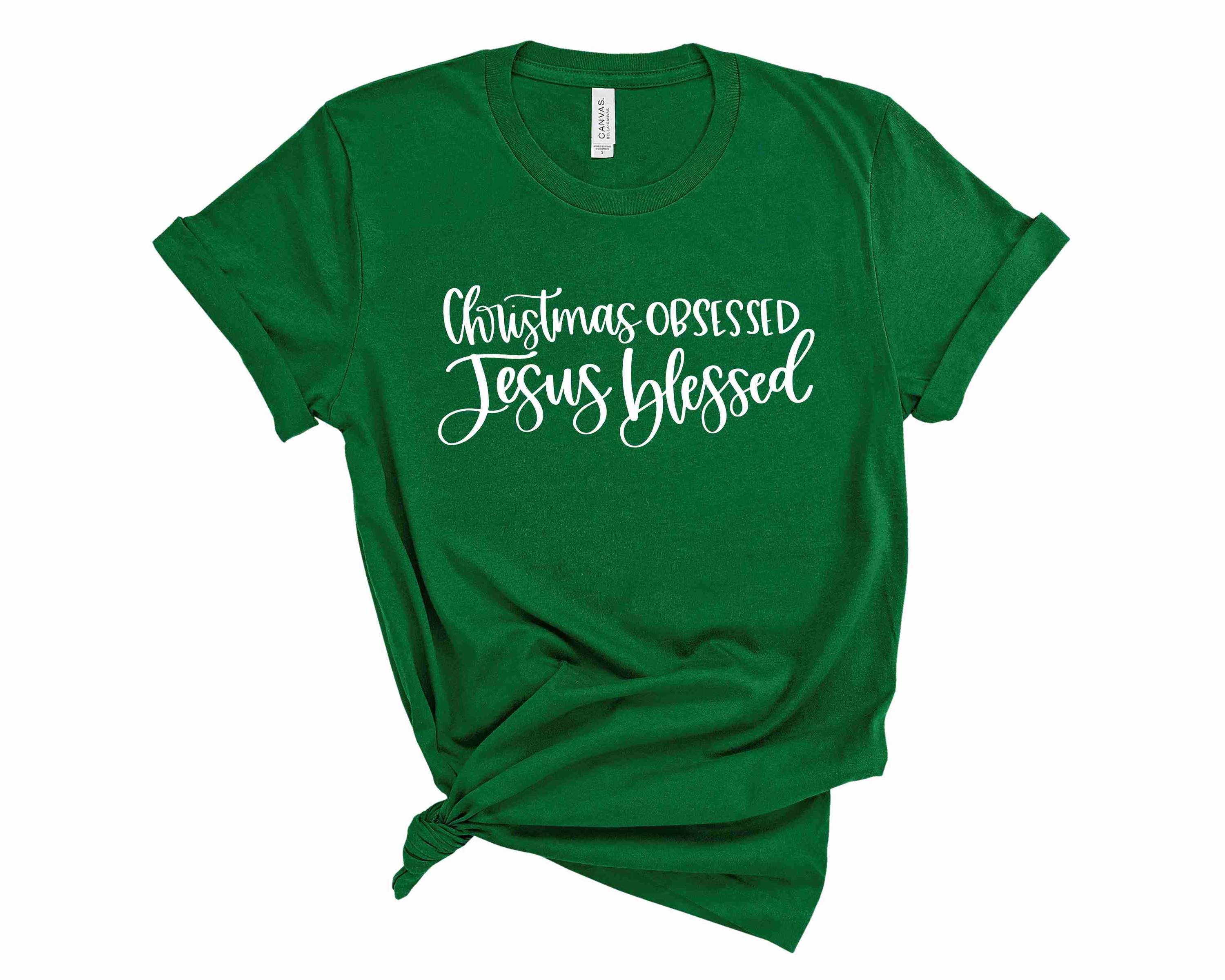 A unisex graphic tee featuring the text 'Christmas Obsessed Jesus Blessed' in vibrant colors, perfect for holiday celebrations.