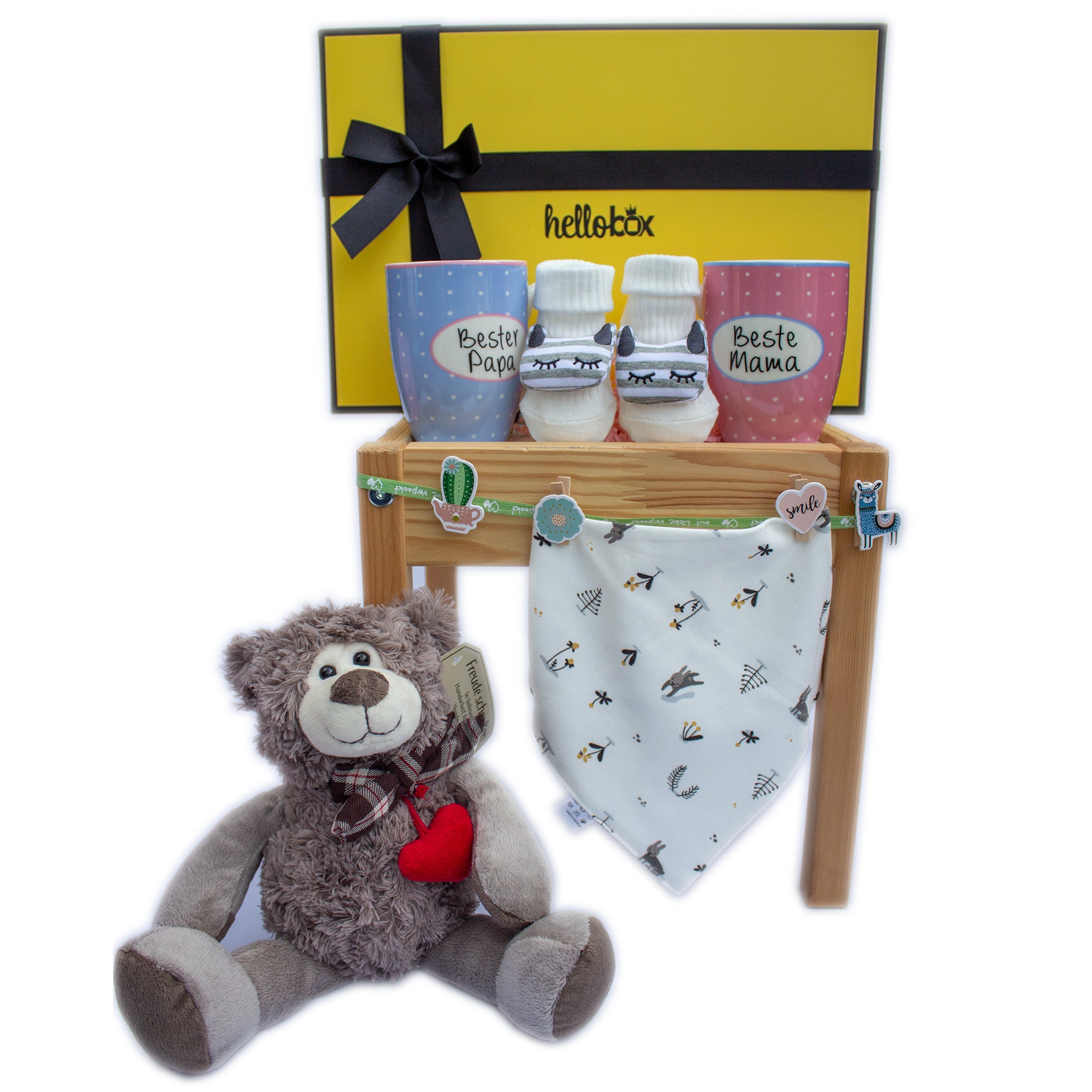 A charming gift set for newborns featuring a soft bear, cozy socks, and a stylish bib, all beautifully packaged in a gift box.
