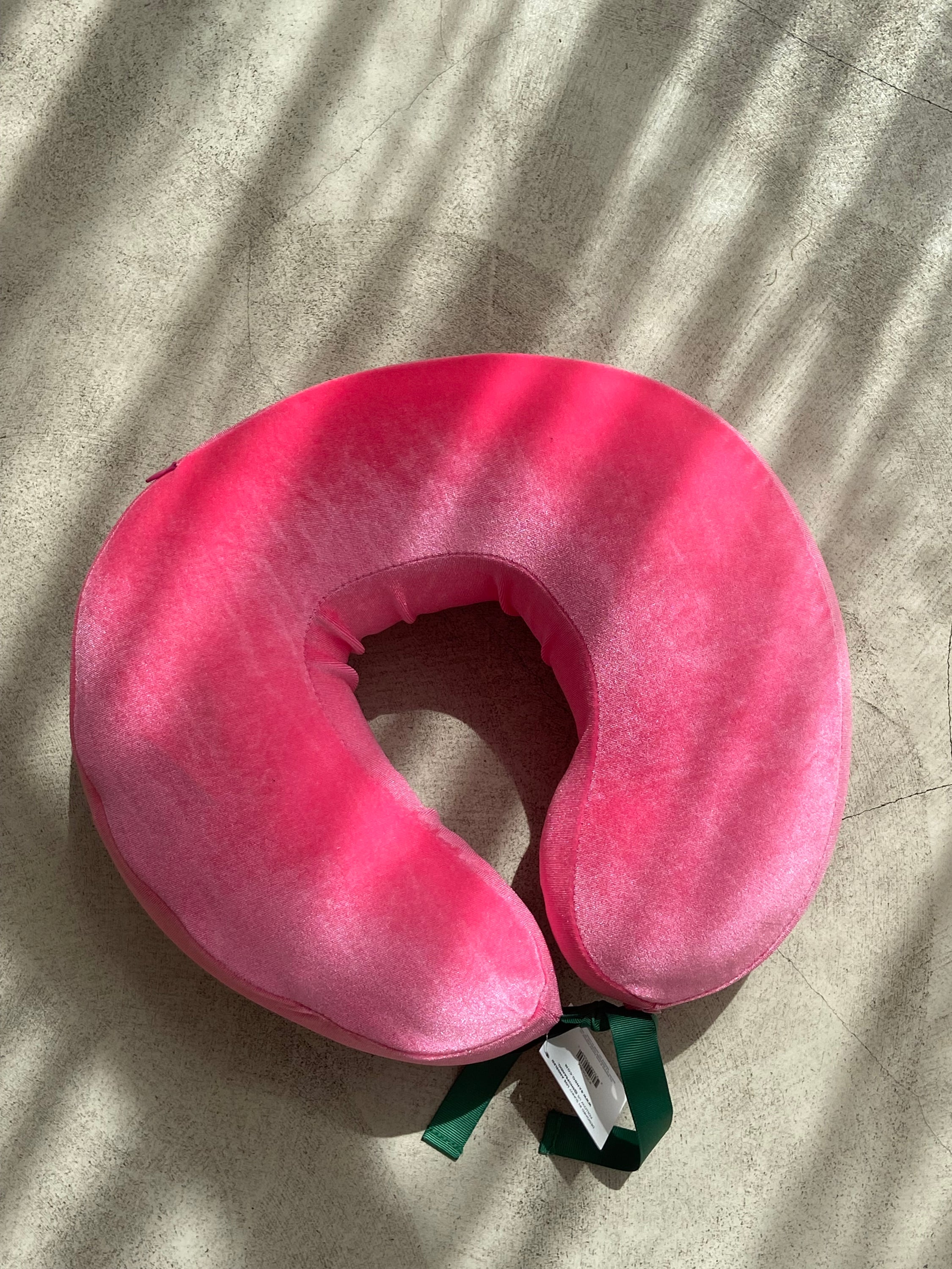 COUSSIN DE VOYAGE travel pillow in pink and yellow, featuring a soft removable cover and satin cord for easy attachment to luggage.