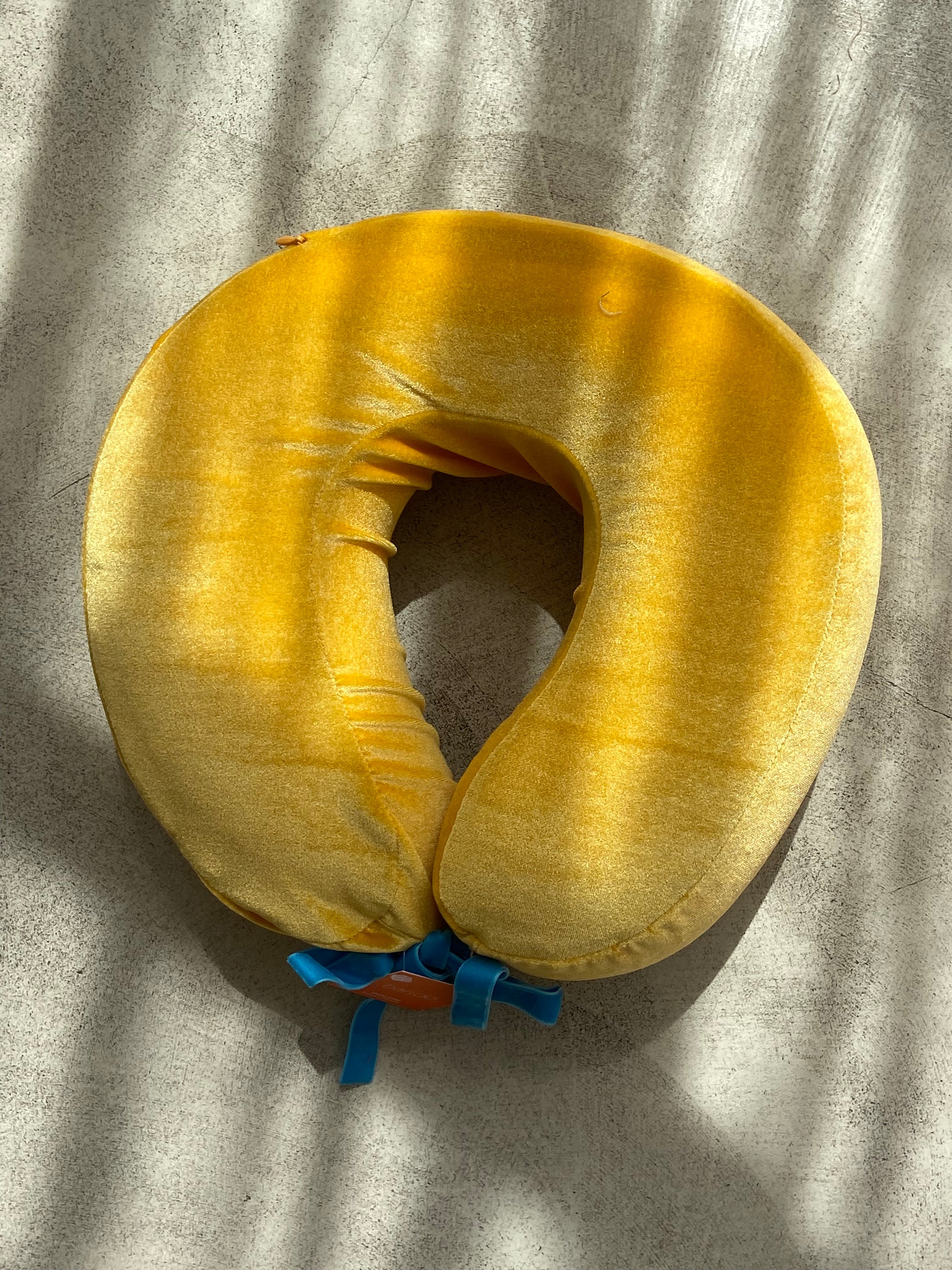 COUSSIN DE VOYAGE travel pillow in pink and yellow, featuring a soft removable cover and satin cord for easy attachment to luggage.