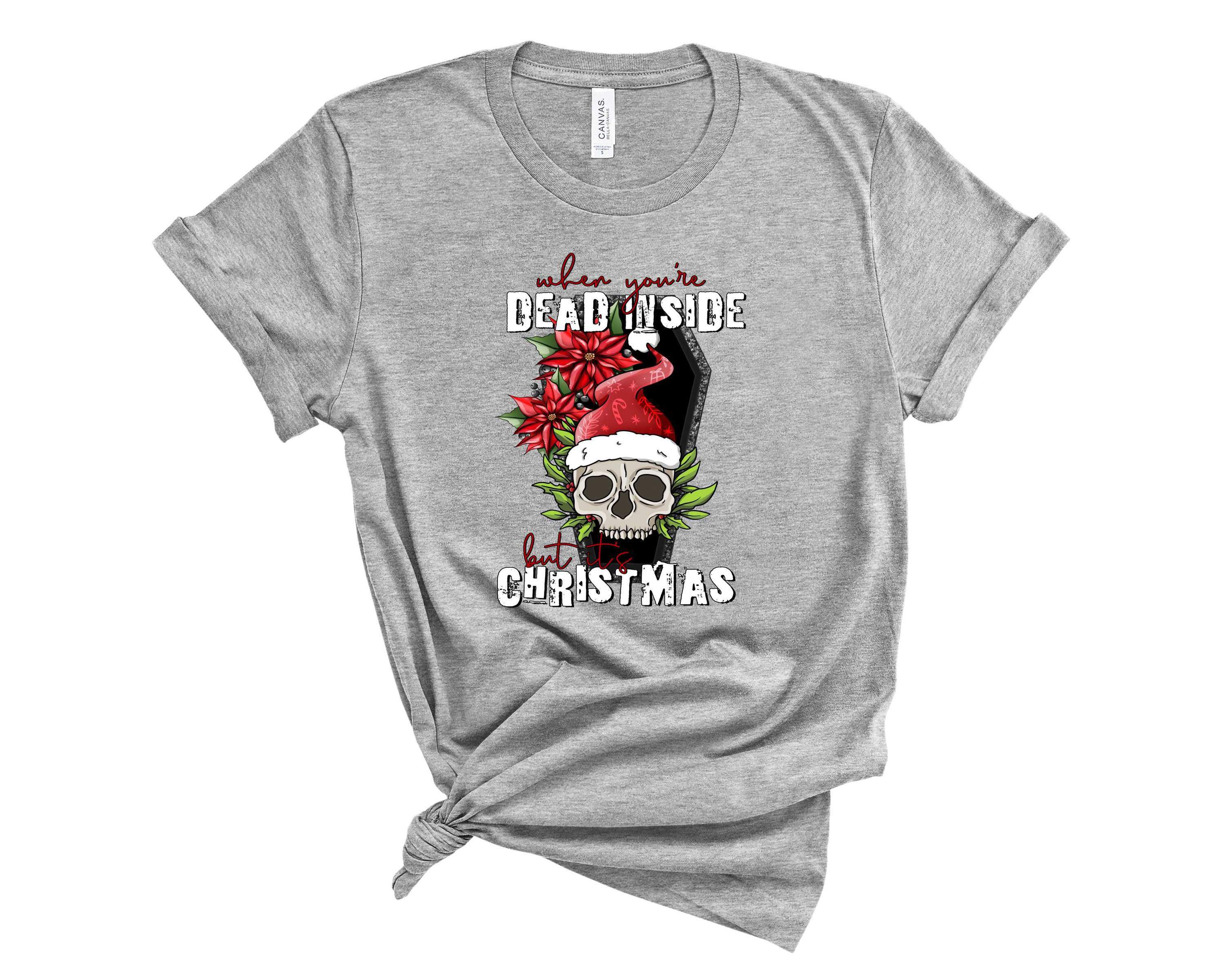 A unisex graphic tee featuring the phrase 'Dead Inside but It's Christmas' in a stylish font, perfect for holiday humor.
