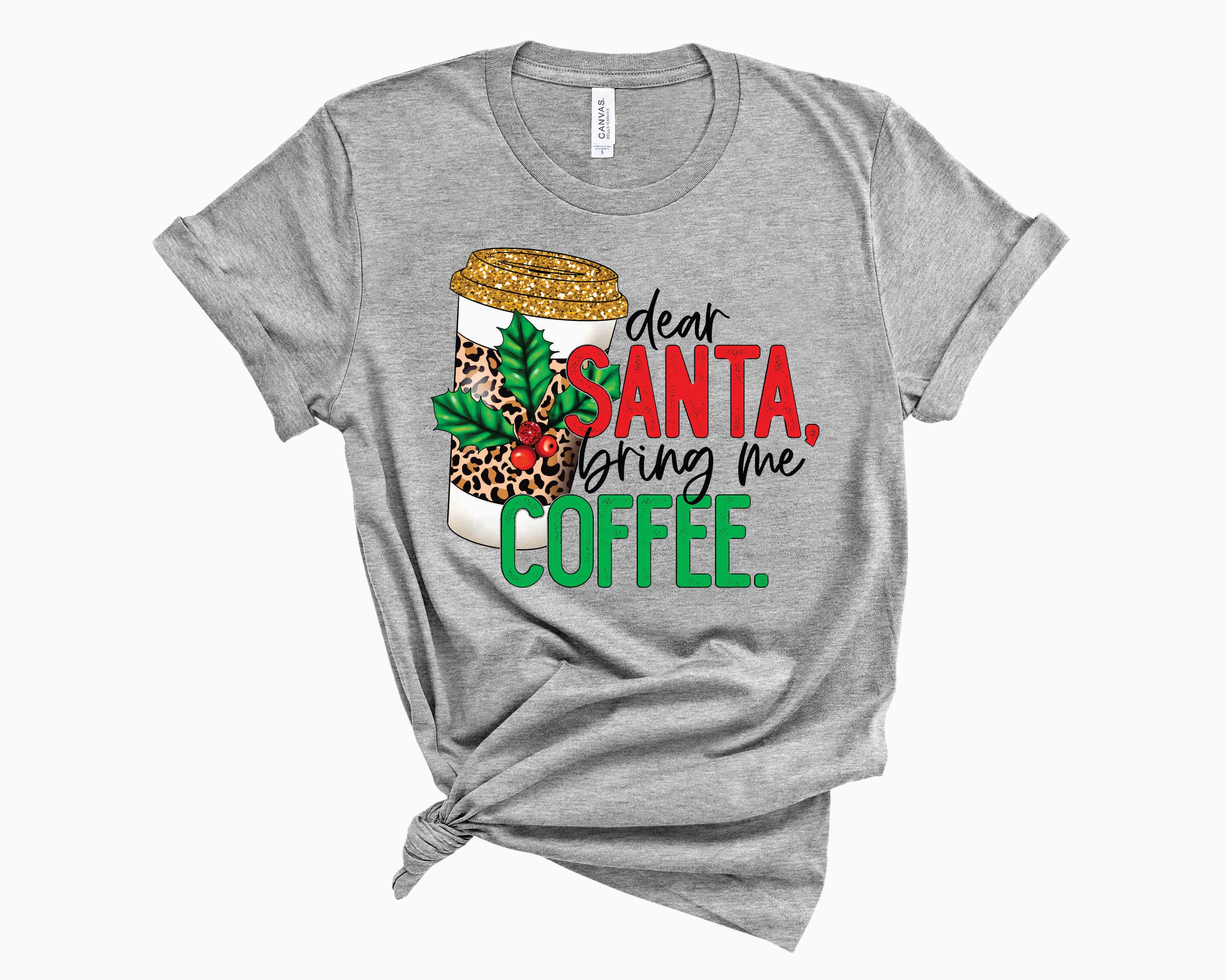 A unisex graphic tee featuring the phrase 'Dear Santa Bring Me Coffee' in a playful font with a stylish leopard print design.